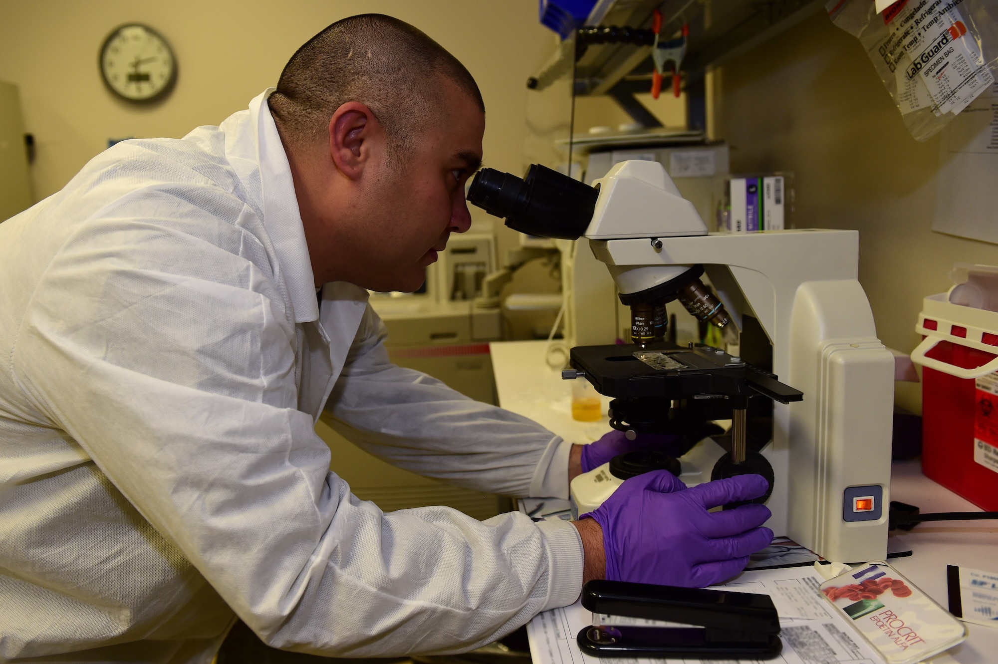 Tech. Sgt. Vincent Gella, 460th Medical Group laboratory element chief, views a patient sample under a microscope August 11, 2016, at the Veterans Affairs Joint Venture Buckley Clinic in Aurora, Colo. The lab provides diagnostic testing services, such as hematology, urinalysis, chemistry, serology, microbiology and pathology based upon the primary care physician’s referrals. (U.S. Air Force photo by Airman 1st Class Gabrielle Spradling/Released)