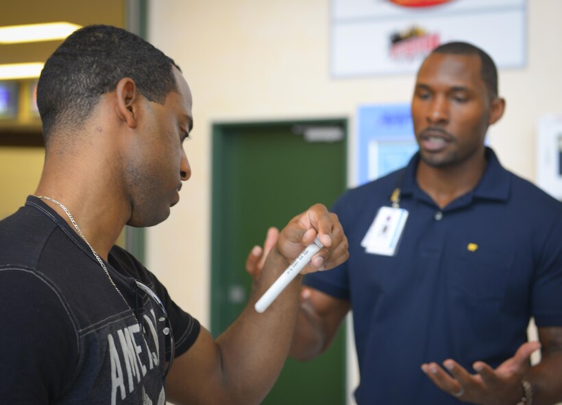 Tech. Sgt. Jeffrey Acosta-Cousar, United States Forces Japan Shared Early Warning System program manager, learns the amount of sugar in a cup of energy drink from Brandon Waller, 374th Aerospace Medicine Squadron Health Promotion Flight director at Yokota Air Base, Japan, Aug. 8, 2016. Waller hopes to use new position as director to help Yokota personnel and families adapt to a healthier lifestyle so that they are ready to complete the mission at all times. (U.S. Air Force Photo by Airman 1st Class Elizabeth Baker/Released)