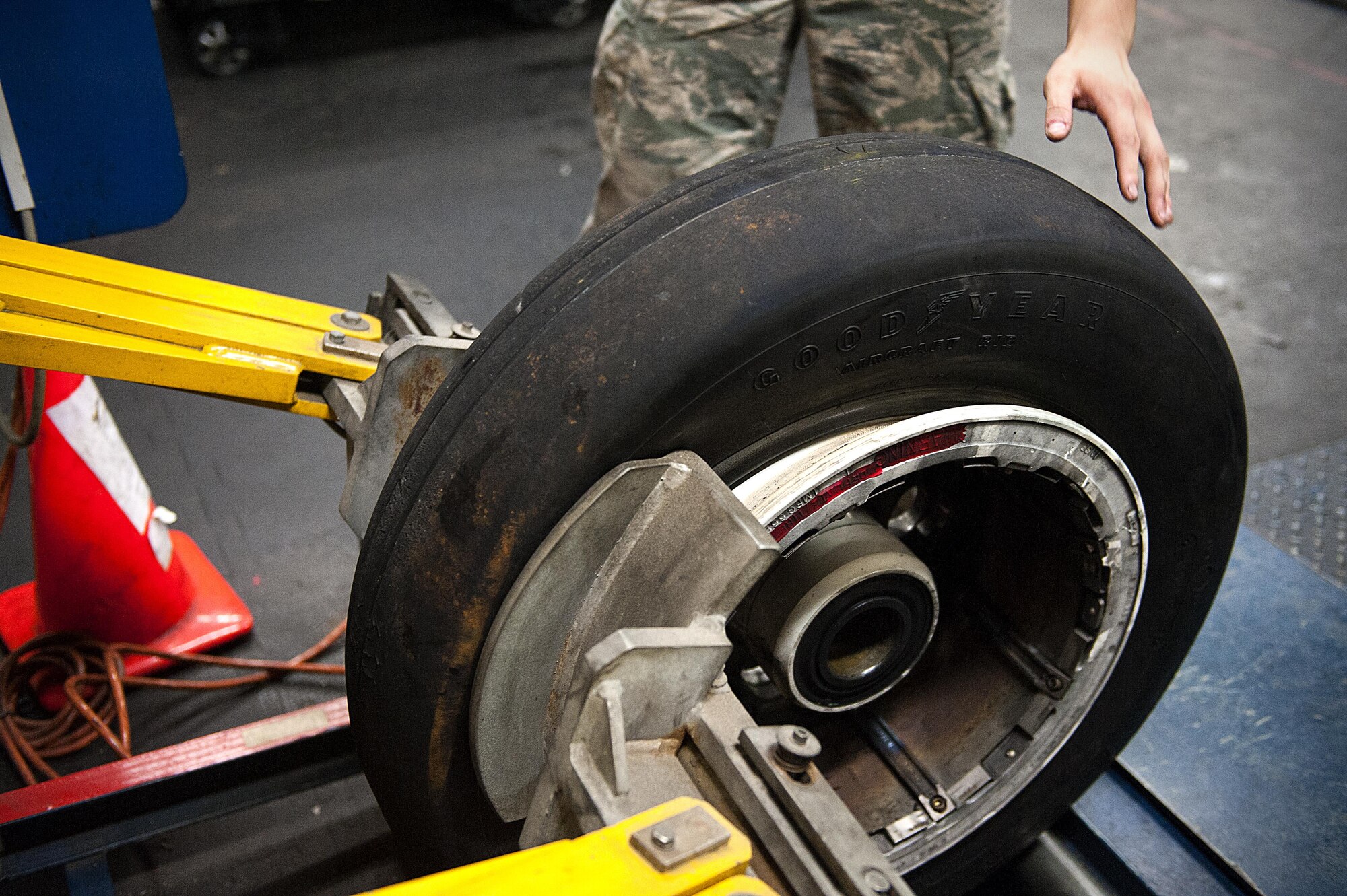 A bead breaking machine pushes on a tire that is about to be taken apart for cleaning and inspection Aug. 10, 2016, at Kadena Air Base, Japan. The edge of the tire, known as the bead, can sometimes get stuck to the wheel when under a lot of pressure. This machine makes it easier for the Airmen to disassemble the wheel. (U.S. Air Force photo by Airman 1st Class Corey M. Pettis)
