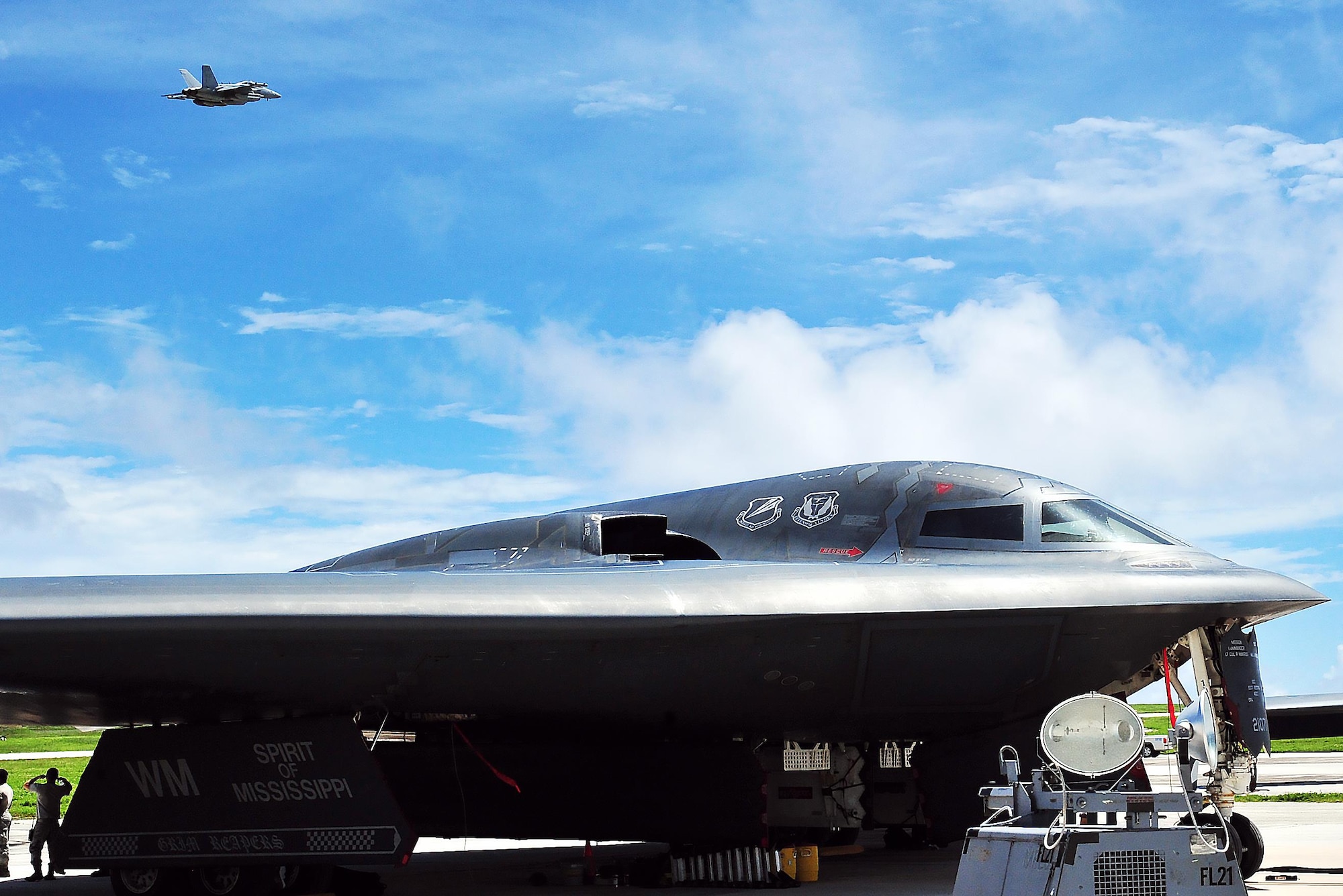 A U.S. Navy EA-18G Growler flies over a U.S. Air Force B-2 Spirit deployed from Whiteman Air Force Base, Mo., Aug. 10, 2016 at Andersen Air Force Base, Guam. Training and theater security cooperation engagements with U.S. allies and partners demonstrate a shared commitment to promoting security and stability. (U.S. Air Force photo by Senior Airman Jovan Banks)