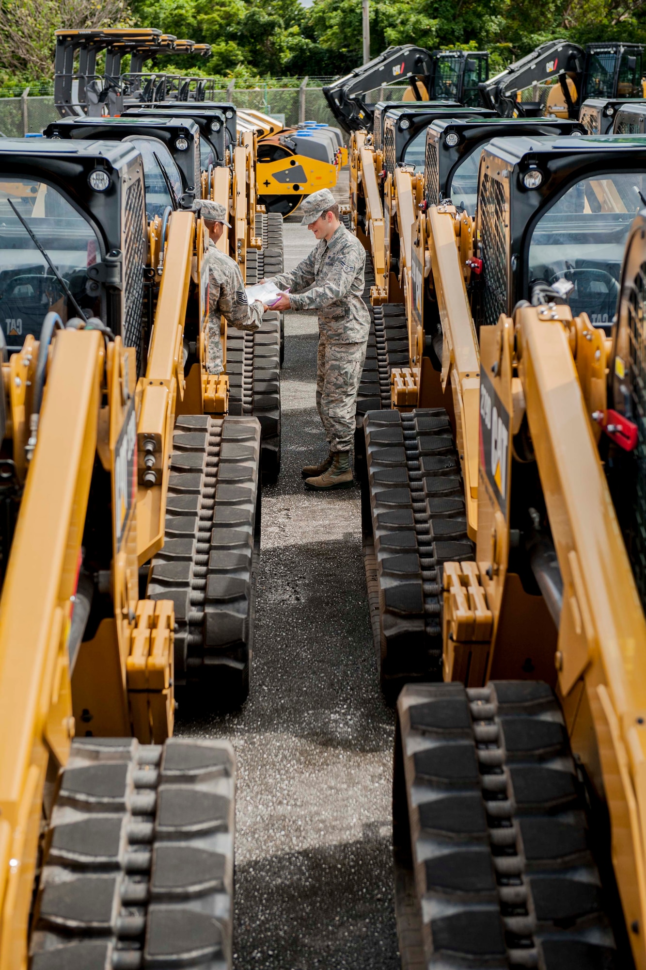 Tech. Sgt. Michael Greene, 18th Logistics Readiness Squadron fleet management and analysis assistant NCO in charge, and Airman 1st Class Quentin Isenberg, 18th LRS FMA analysis apprentice, check pile tags on new skid-steer loaders Aug. 11, 2016, at Kadena Air Base, Japan. Greene and Isenberg inspect all new vehicles being added to their fleet for quality and maintenance standards before sending them to mechanics for servicing. (U.S. Air Force photo by Senior Airman Peter Reft)