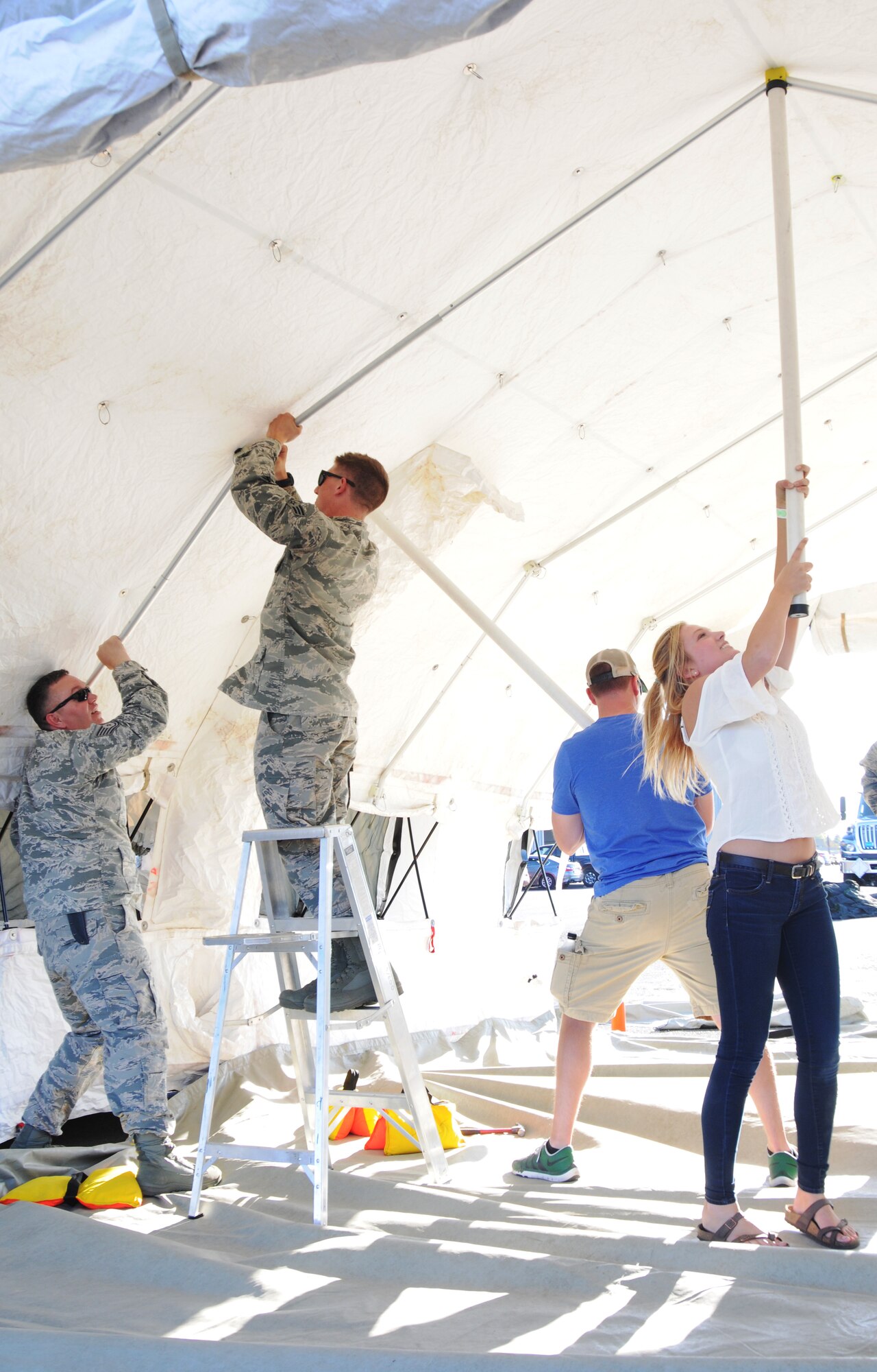 Members of the 142nd Fighter Wing set up a tent used to display historical items as part of the 75th Anniversary of the Oregon Air National Guard during the Oregon International Air Show in Hillsboro, Ore., Aug. 5, 2016. (U.S. Air National Guard photo by Tech. Sgt. John Hughel, 142nd Fighter Wing Public Affairs/Released).
