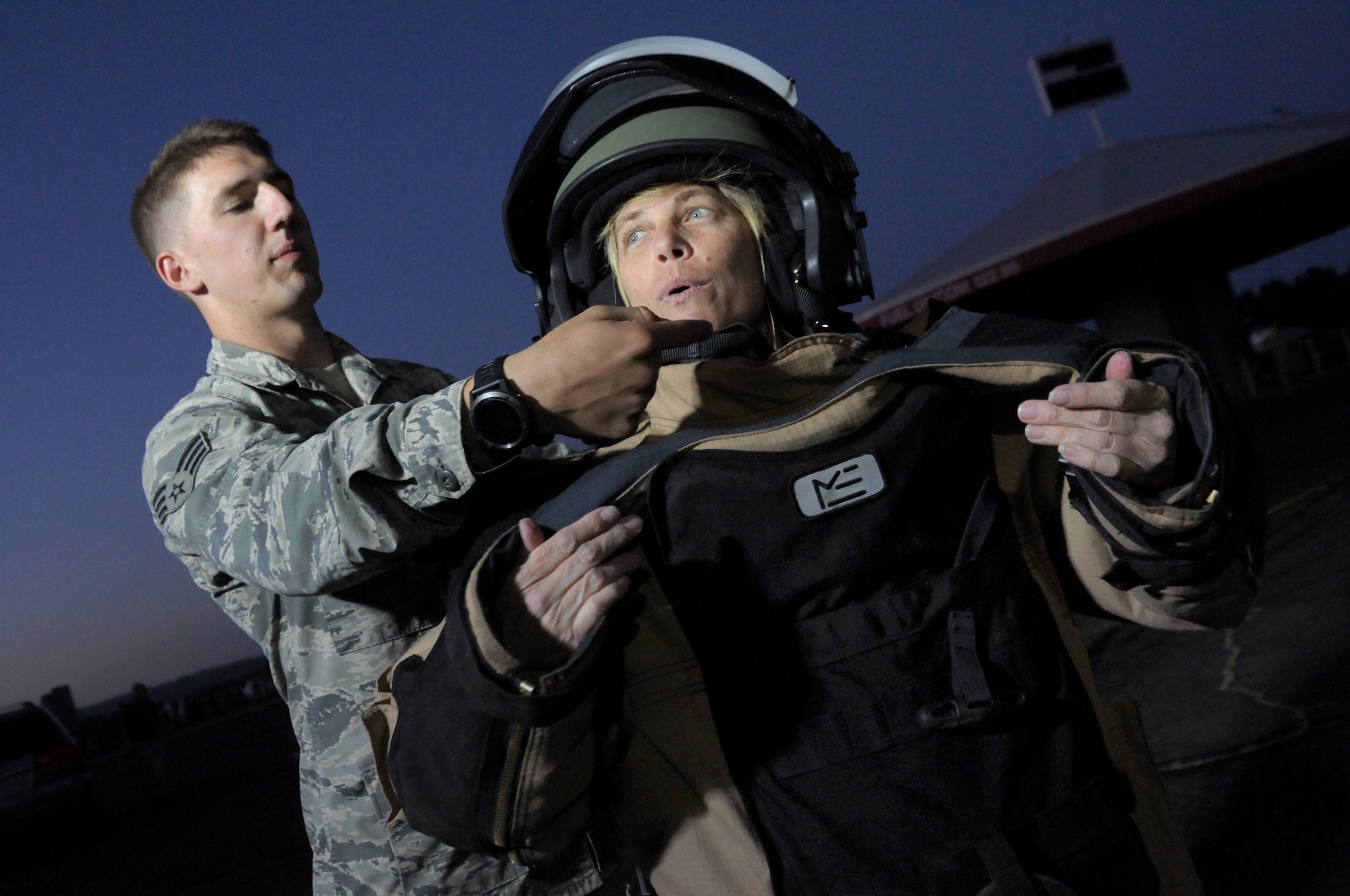 Oregon Senior Airman Alec Camp, an explosive ordinance disposal technician assigned to the 142nd Civil Engineer Squadron helps Sherrie Speck try on protective equipment used to secure explosive materials during the Oregon International Air Show, Hillsboro, Ore., Aug. 5, 2016. (U.S. Air National Guard photo by Tech. Sgt. John Hughel, 142nd Fighter Wing Public Affairs/Released).