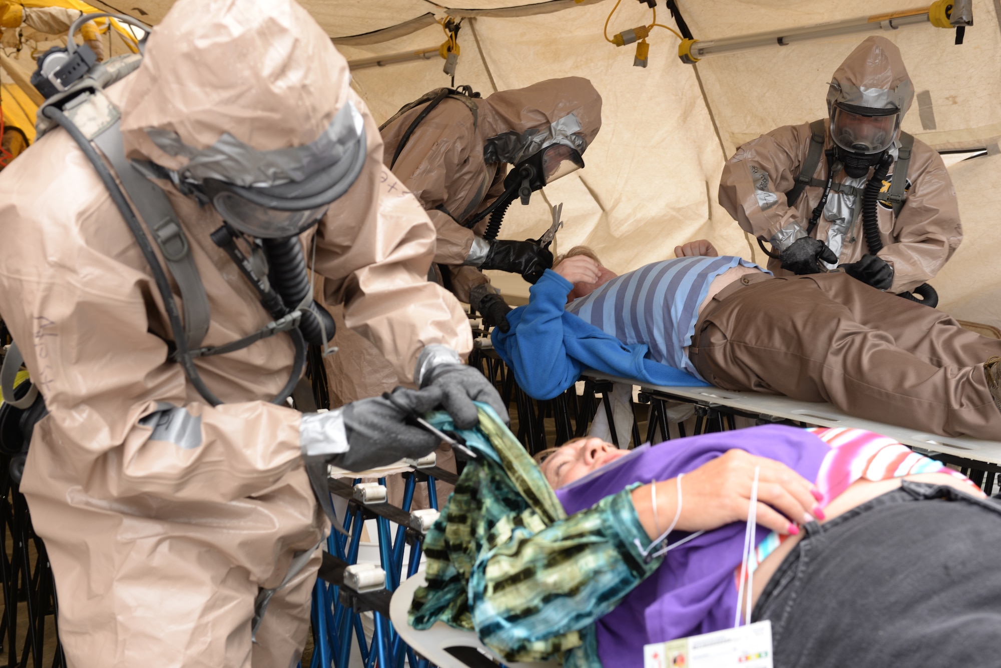 U.S. Colorado National Guard Airmen and Soldiers, cut clothes off simulated civilan victims to train for the joint exercise evaluation (EXEVAL), where they will be evaluated for wartime readiness at Camp Rilea, Warrenton, Oregon, Aug. 2, 2016. This portion of the evaluation was mid-week, where the pace picked up moderately and led into the most demanding challenge on the fifth day, the evaluation. (U.S. Air National Guard photo by Staff Sgt. Bobbie Reynolds) 
