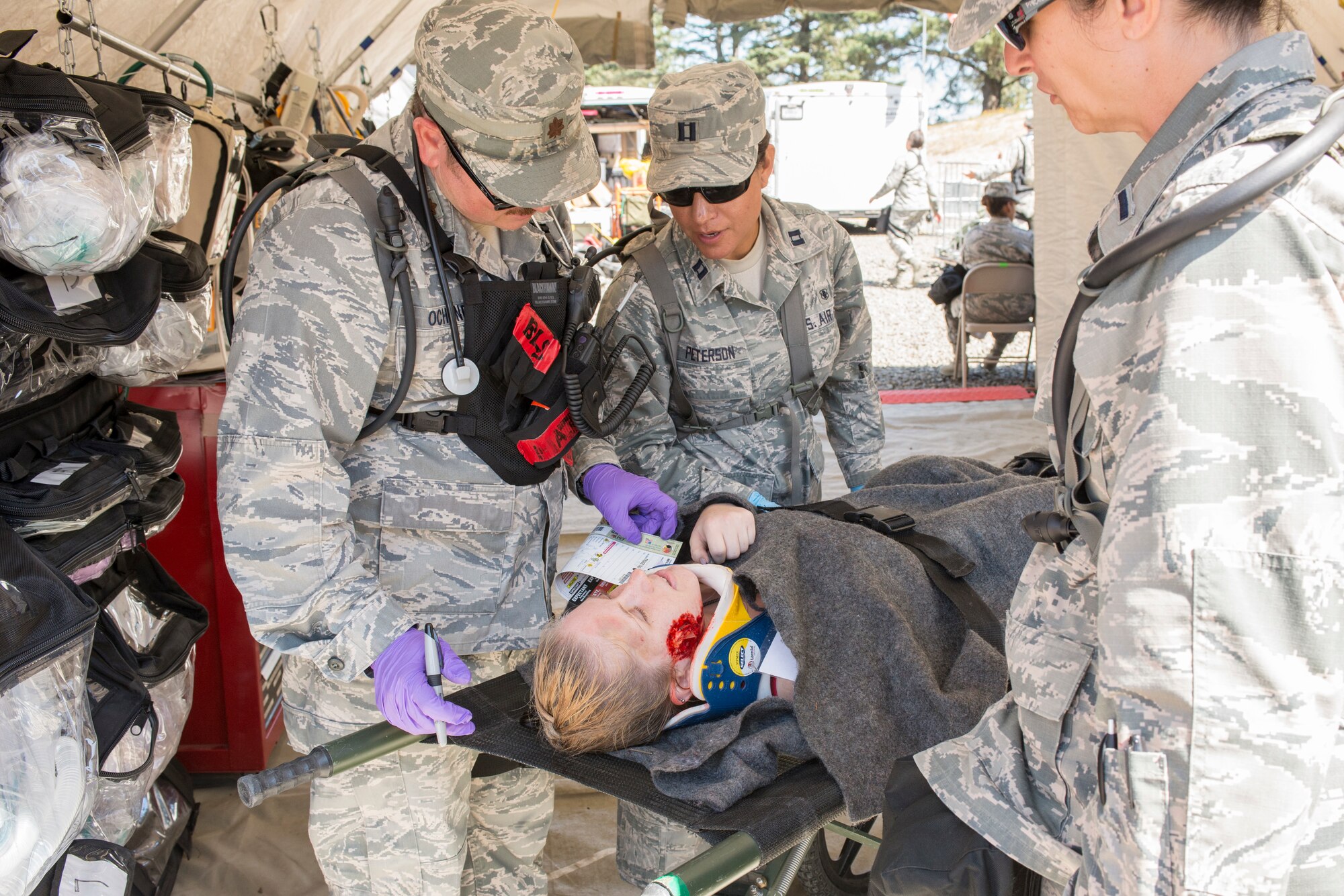 (From the left) Maj. Robert J. Ochsner, basic life support physician, Capt. Alex P. Peterson, nurse practitioner and 2nd Lt. Margaret J. Mazzarello, nurse practitioner, all assigned to the 140th Medical Group, Buckley Air Force Base, Colo. examine a patient in triage for internal and external wounds during the joint exercise evaluation (EXEVAL), held at Camp Rilea, Warrenton, Oregon, on Aug. 4, 2016. The EXEVAL ran for five days in a crawl, walk, run sequence, where they started off slowly, then transitioned into rapid response on evaluation day. (U.S. Air National Guard photo by Staff Sgt. Bobbie Reynolds) 