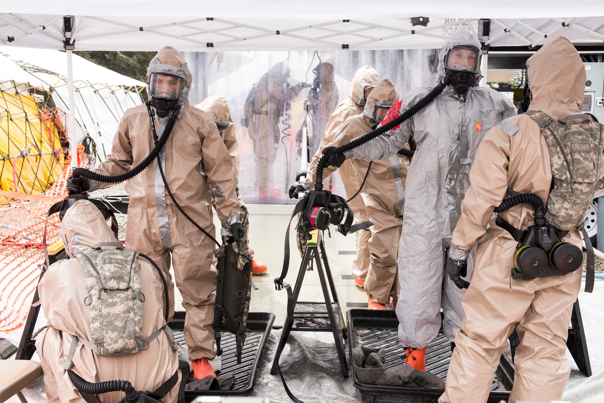 Colorado Army National Guard Soldiers move through the decontamination tent, where they are sprayed down thoroughly and checked for any signs of chemical, biological, radiological or nuclear residual, in an effort to train for a joint exercise evaluation (EXEVAL), where they'll be evaluated for war time readiness at Camp Rilea, Warrenton, Oregon, on Aug. 3, 2016. The EXEVAL scenerios changed every day, giving Soldiers and Airmen the opportunity to practice in multiple atmospheres with various personnel. (U.S. Air National Guard photo by Staff Sgt. Bobbie Reynolds) 
