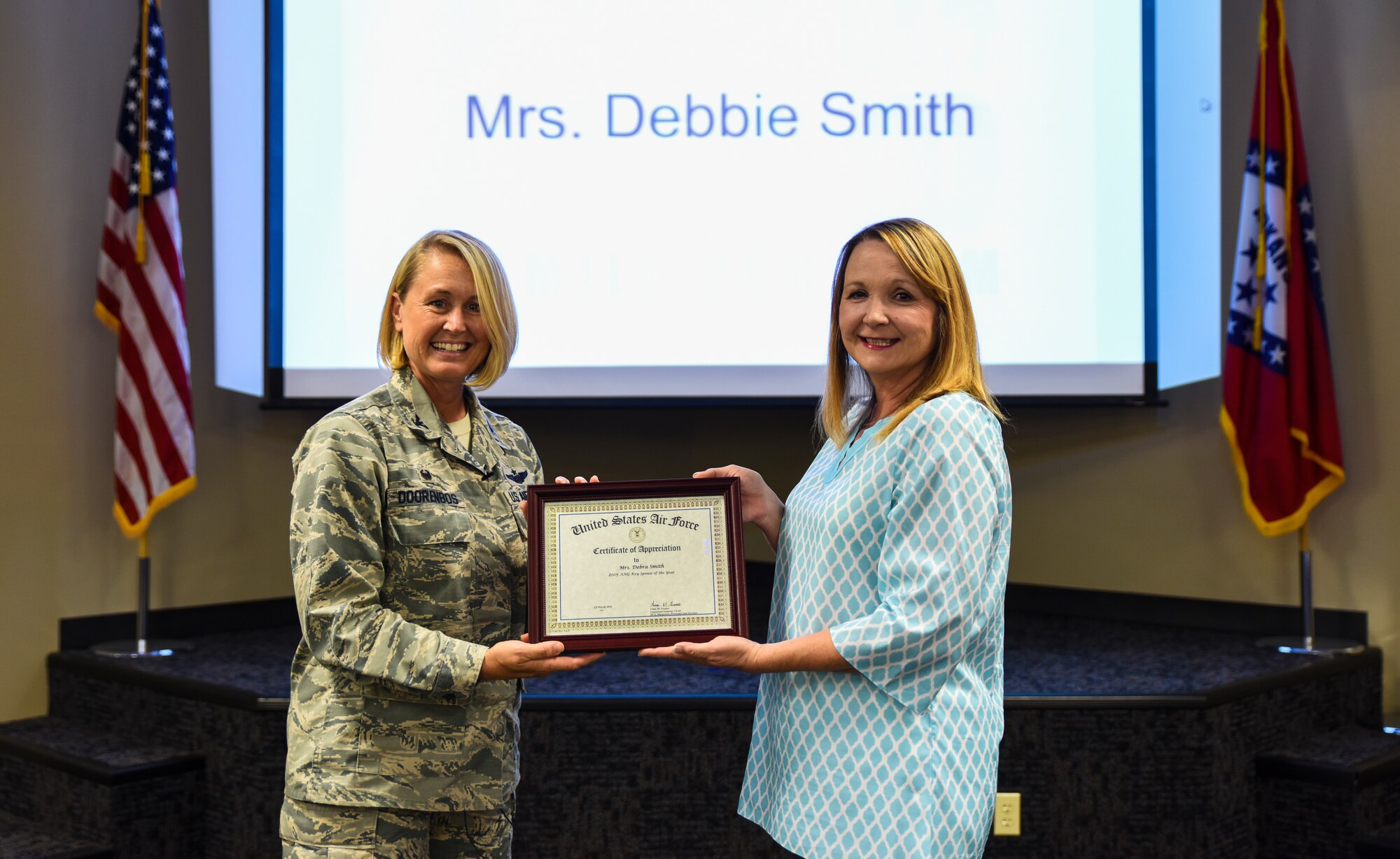 Debbie Smith, key volunteer, is presented the 2015 Air National Guard Key Spouse of the Year award by Col. Bobbi Doorenbos, 188th Wing commander, Aug. 6, 2016, for being an invaluable member of the 188th Airman and Family Readiness Office's Key Volunteer Program and a proven leader with her husband, Col. Thomas Smith, at Ebbing Air National Guard Base, Fort Smith, Ark. Smith has also previously won the 2013 and 2015 Wing Volunteer of the Year award and the 2015 Region Six Volunteer of the Year award. (U.S. Air National Guard photo by Senior Airman Cody Martin)