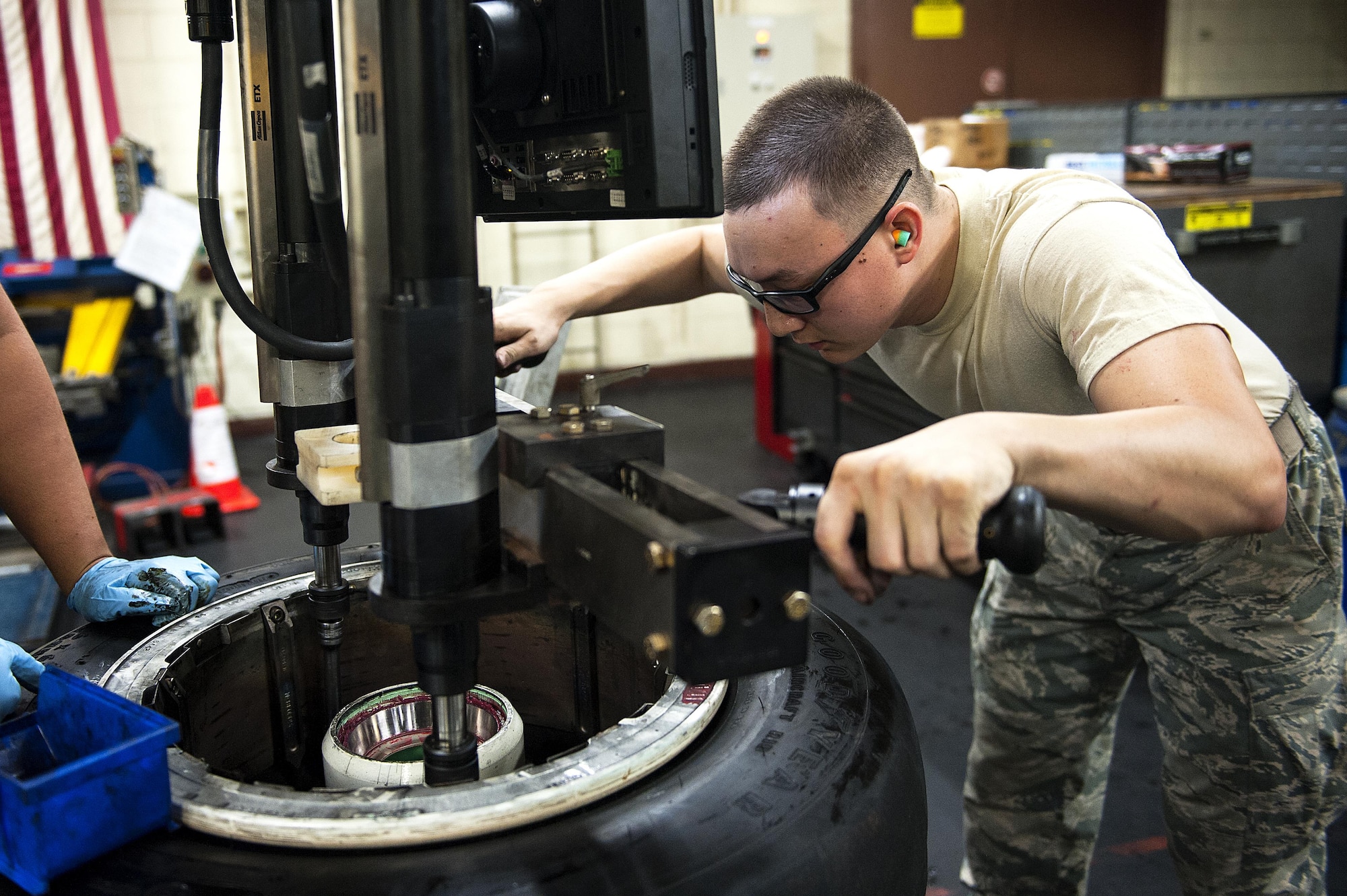 Senior Airman Joel Waller, 18th Equipment Maintenance Squadron wheel and tire technician, unscrews the bolts on an aircraft wheel Aug. 10, 2016, at Kadena Air Base, Japan. The wheels and tires must be separated, washed and inspected before going back out to be put on an aircraft. (U.S. Air Force photo by Airman 1st Class Corey M. Pettis)