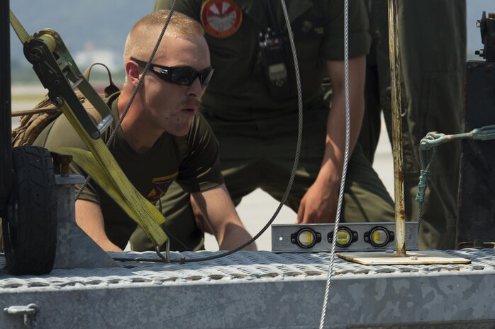 U.S. Marine Corps Cpl. William Norkus, a port crew leader with Aircraft Recovery assigned to Headquarters and Headquarters Squadron, confirms the mobile Expeditionary Hover Position Indicator is level at Marine Corps Air Station Iwakuni, Japan, Aug. 9, 2016. The aircraft recovery Marines worked to set up the mobile EHPI to provide pilots from Marine Attack Squadron (VMA) 542 an opportunity to recertify in boat-deck landings before departing for other future operations in the Pacific. Home based out of Marine Corps Air Station Cherry Point, N. C., VMA-542 is forward deployed as part of the unit deployment program at MCAS Iwakuni and is strengthening their aviation operational skills with the station’s units while abroad. (U.S. Marine Corps photo by Lance Cpl. Donato Maffin)