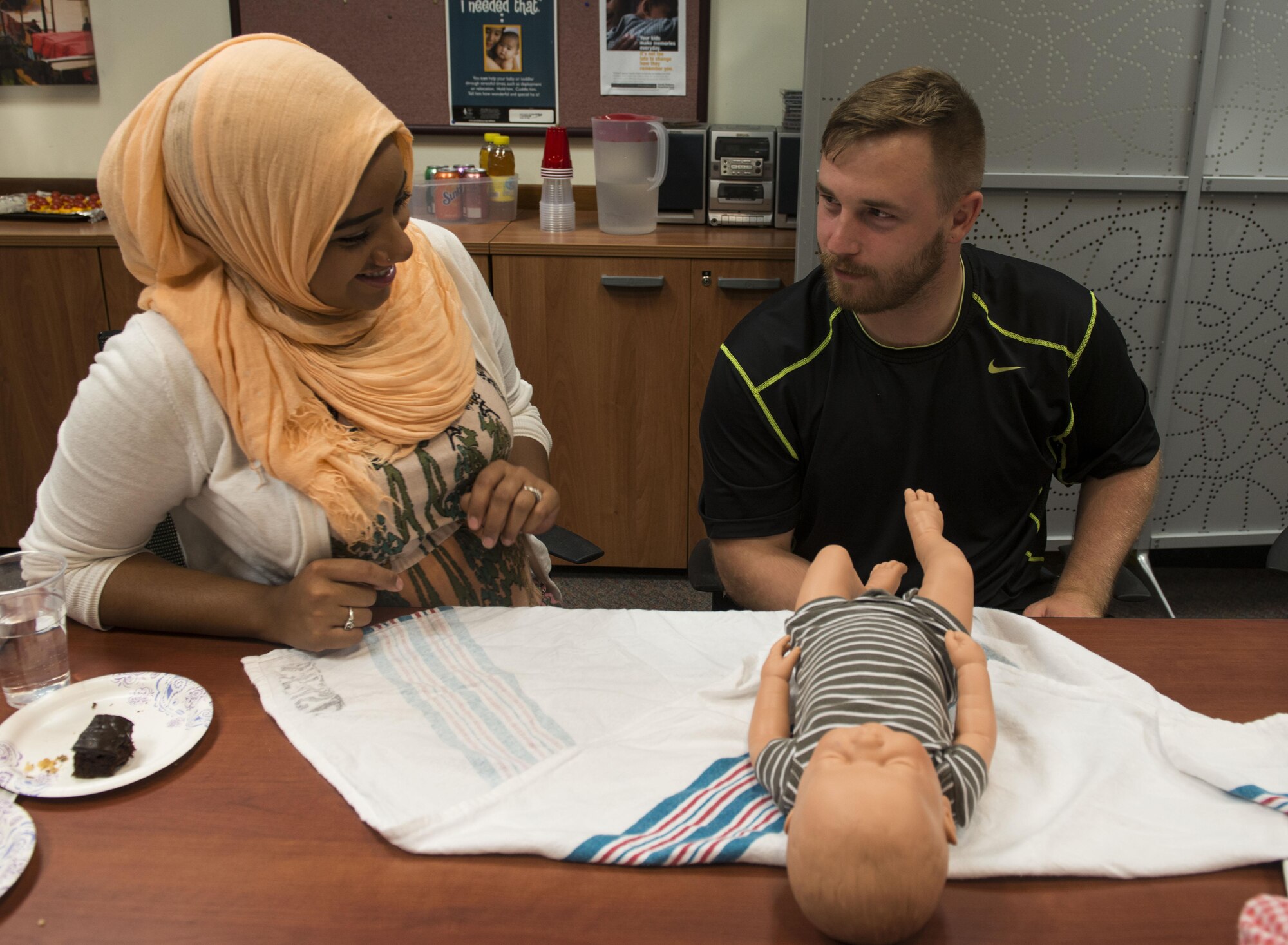Airman 1st Class Andrew Rux, 31st Security Forces Squadron security controller, and his wife, Ahlam Bussuri, practice swaddling an infant during a Baby Basic Training class on August 4, 2016, at Aviano Air Base, Italy. The two-part class teaches expecting parents about basic care and safety for infants, child development and the importance of breastfeeding. (U.S. Air Force photo by Senior Airman Krystal Ardrey/Released)