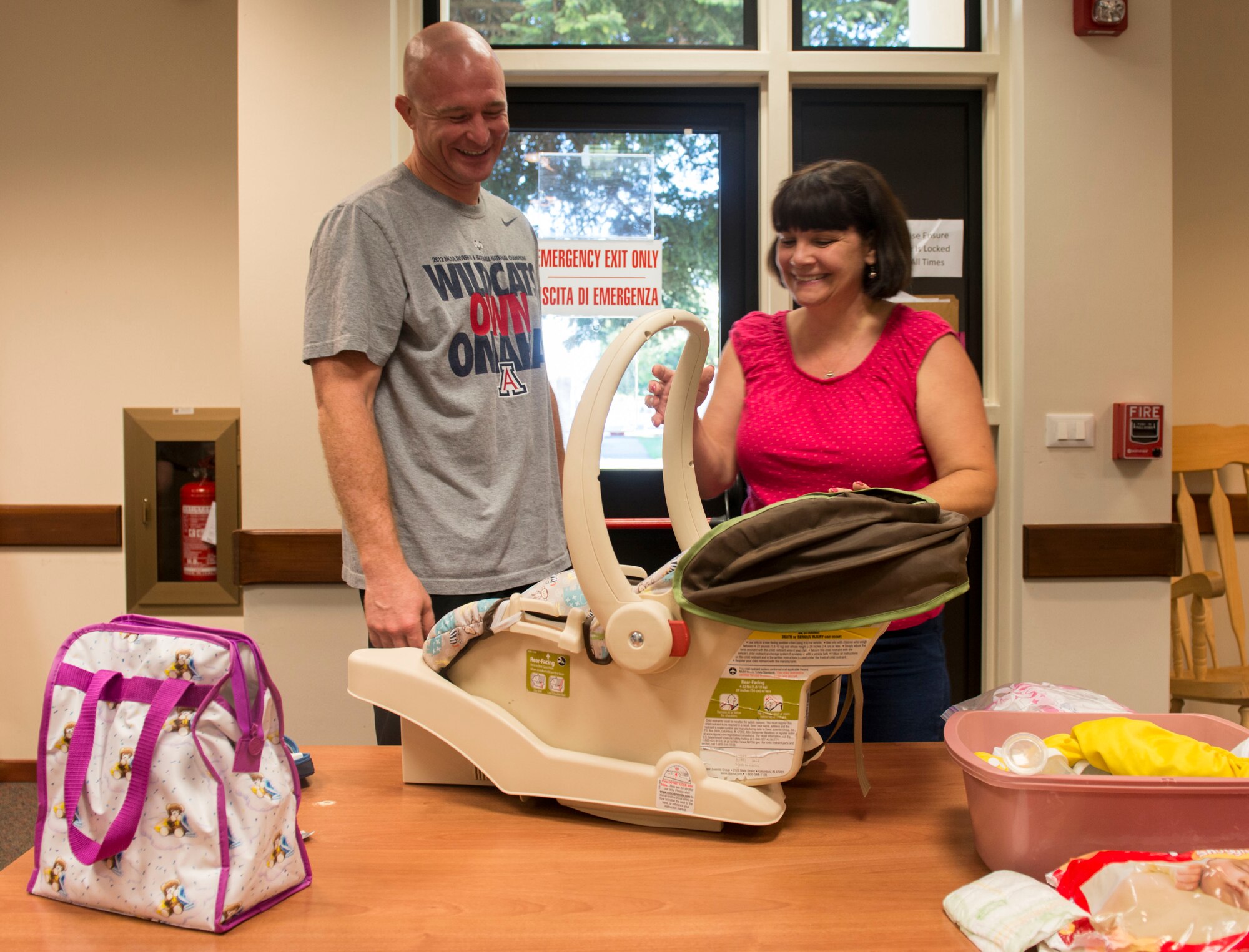 Cynthia Cusimano, 31st Medical Operations Squadron Family Advocacy nurse, teaches Staff Sgt. Les Busser, 31st Logistics Readiness Squadron NCO in-charge of fuels laboratory, how to use a car seat correctly during a Baby Basic Training on August 4, 2016, at Aviano Air Base, Italy. Family Advocacy offers three main support options to expecting parents: prenatal home visits, Baby Basic Training and a Boot Camp for New Dads class. (U.S. Air Force photo by Senior Airman Krystal Ardrey/Released)