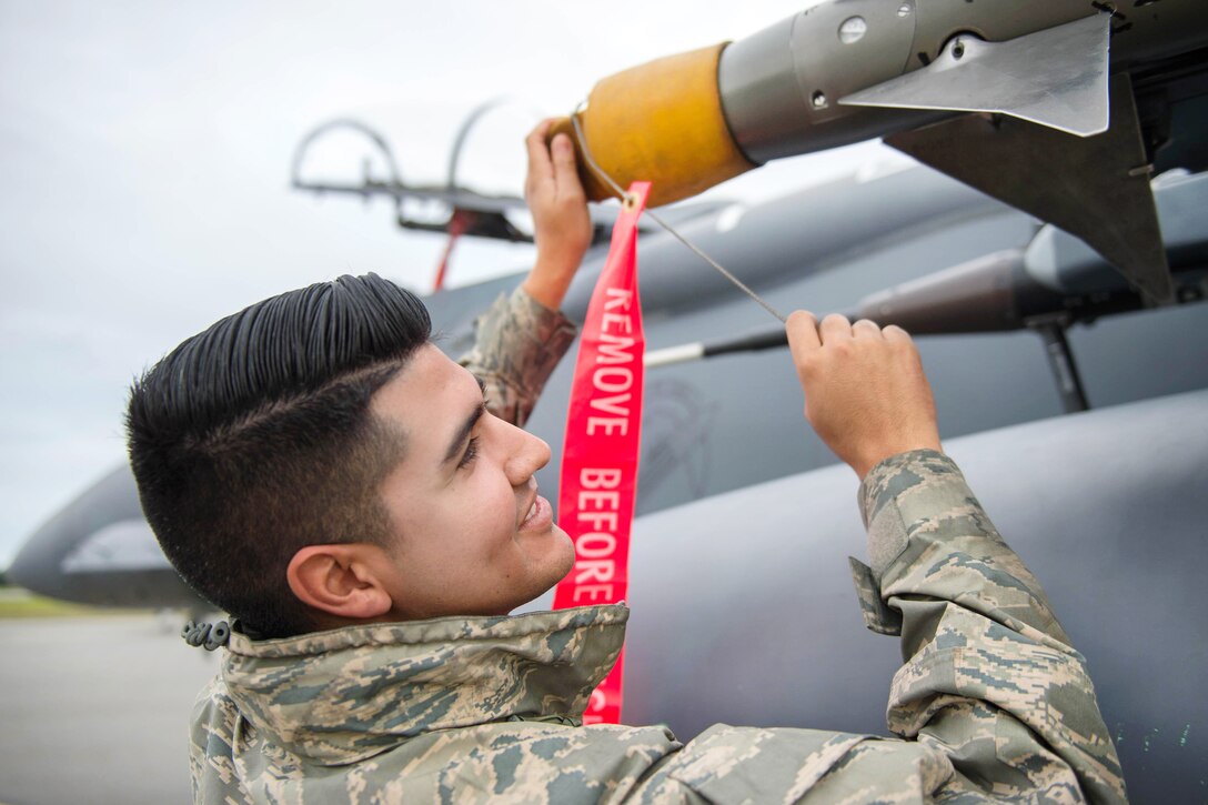 Air Force Senior Airman Christian Garibay removes a cover from electronic attack equipment on an Air Force F-15E Strike Eagle aircraft during Red Flag Alaska 16-3 at Eielson Air Force Base, Alaska, Aug. 5, 2016. Garibay is a weapons loader assigned to the 336th Aircraft Maintenance Unit. Red Flag is a field training exercise in which U.S. and allied forces provide joint offensive counter-air, interdiction, close air support and large force employment training in a simulated combat environment. Air Force photo by Staff Sgt. Shawn Nickel