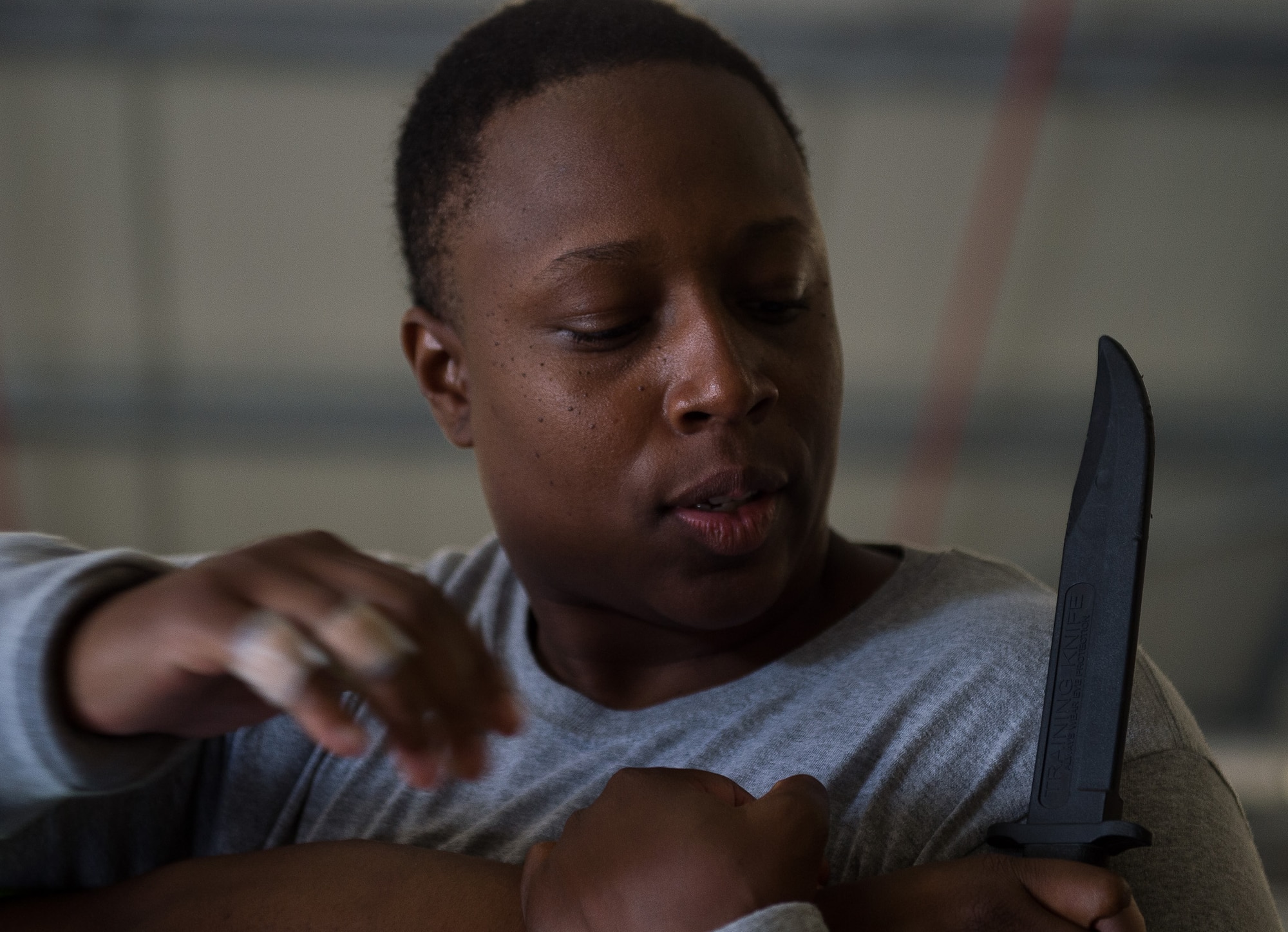U.S. Air Force Staff Sgt. LaDonna Winston, 435th Security Forces Squadron ground regional training center instructor, reaches to grab a knife during an exercise August 5, 2016, at Ramstein Air Base, Germany. Winston practiced the maneuver over and over until she successfully overpowered her attacker. (U.S. Air Force photo/Airman 1st Class Savannah L. Waters)
