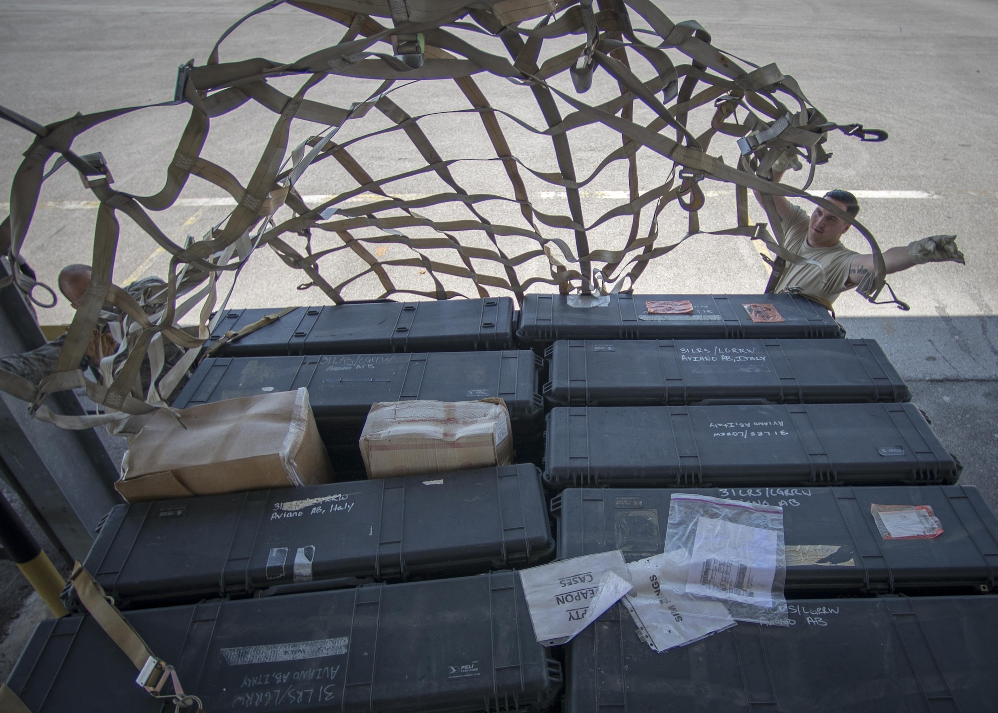 Staff Sgt. Patrick Staunton and Senior Airmen Cameron Jones, 31st Maintenance Squadron phase inspection team members, participate in cargo preparation and pallet buildup training Aug. 8, 2016, at Aviano Air Base, Italy. Nets and straps are used to secure the aircraft’s cargo onto pallets. The straps are tested to withstand up to eight Gs during transportation. (U.S. Air Force photo/Airman 1st Class Cory W. Bush)