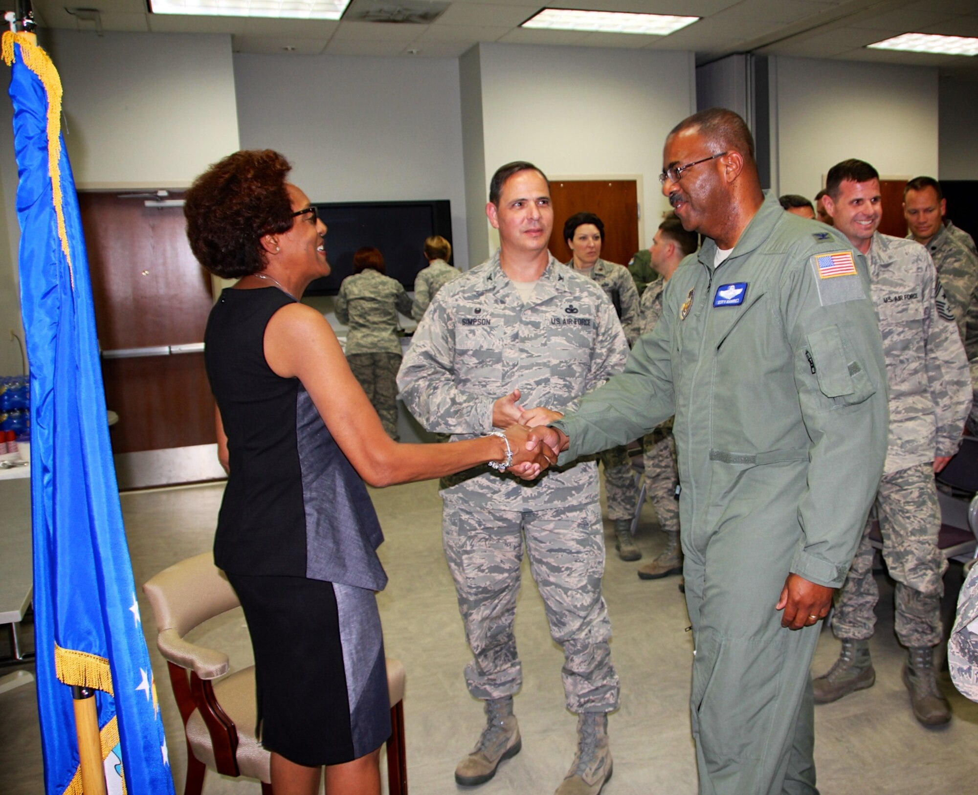 The vice commander of the 932nd Airlift Wing, Col. Esty Ramirez, shakes hands with retiring 932nd Medical Group commander Col. Vanessa Mattox, as Col. Christopher Simpson, 932nd Mission Support Group commander listens.  Colonel Ramirez talked to the large military group of well wishers in the audience about his first time in Illinois at the unit and the fond memories he had meeting Colonel Mattox.  He then presented a special world globe and noted her outgoing leadership style, just as she reminded everyone to have fun along the way, and take care of each other while doing the mission.  (U.S. Air Force photo by Maj. Stan Paregien)