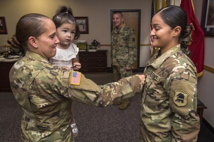 Staff Sgt. Janet Medina, left, pins staff sergeant rank on her daughter, Justina Medina, during a promotion ceremony at the New Jersey Department of Military and Veterans Affairs, Lawrenceville, N.J., August 11, 2016. 