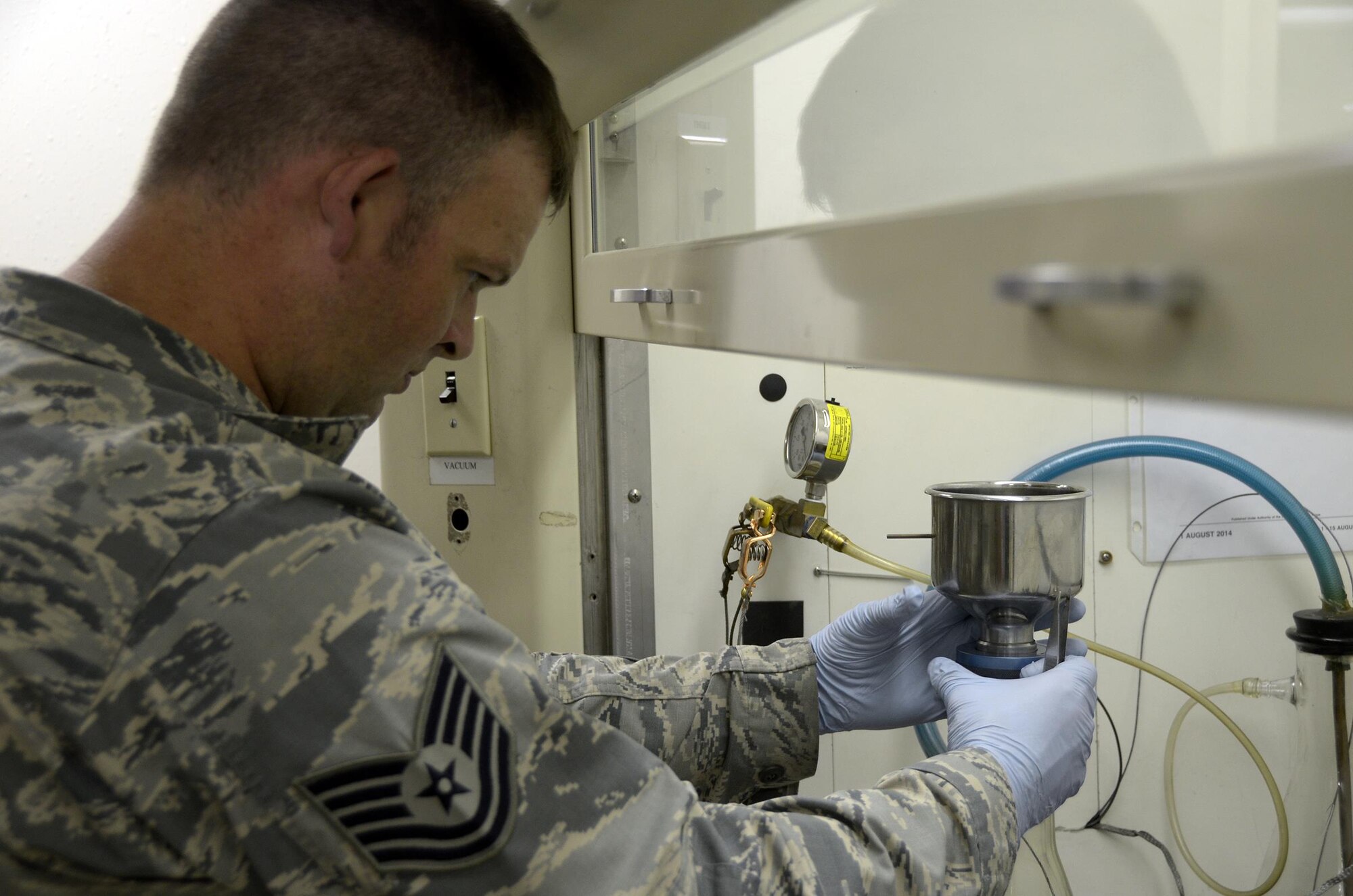 Tech. Sgt. Richard Blake, 445th Logistics Readiness Squadron fuels flight training manager, Wright-Patterson Air Force Base, Ohio, performs a bottle method test on fuel pulled from a refueling truck July 25, 2016 here. Fuel tested is completed in a vacuumed cell for proper ventilation. The 445 LRS augmented the 673rd LRS during their annual tour July 18 – Aug. 1, 2016. (U.S. Air Force photo/Staff Sgt. Joel McCullough)