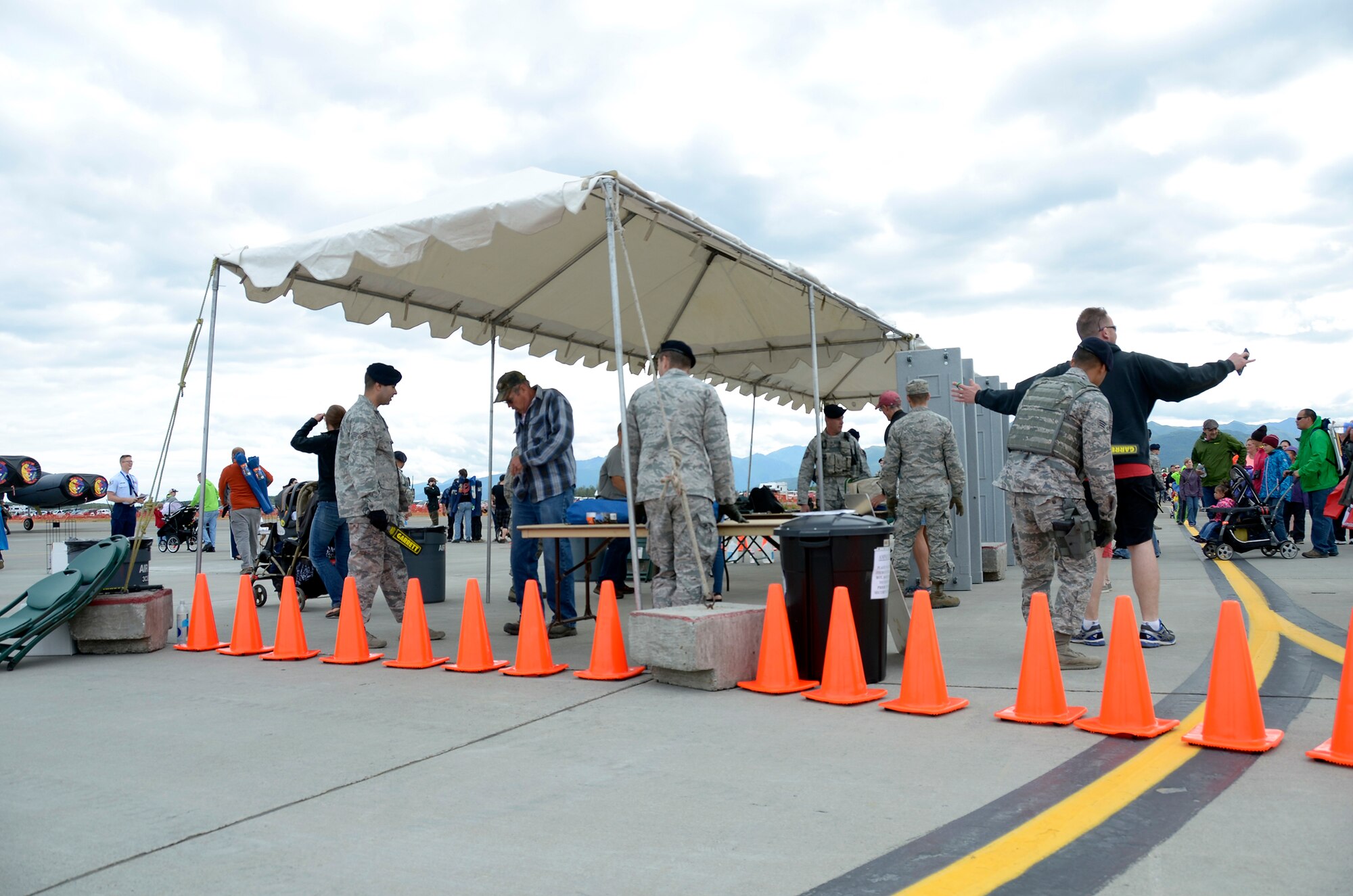 Defenders from the 445th Security Forces Squadron, Wright-Patterson Air Force Base, Ohio, work alongside security forces Airmen from here as they perform security checks at the entrance to the Arctic Thunder Open House July 30, 2016, here. The Reservists assisted the home SFS squadron with guard duties and security details during the two-day open house. (U.S. Air Force photo/Staff Sgt. Joel McCullough)