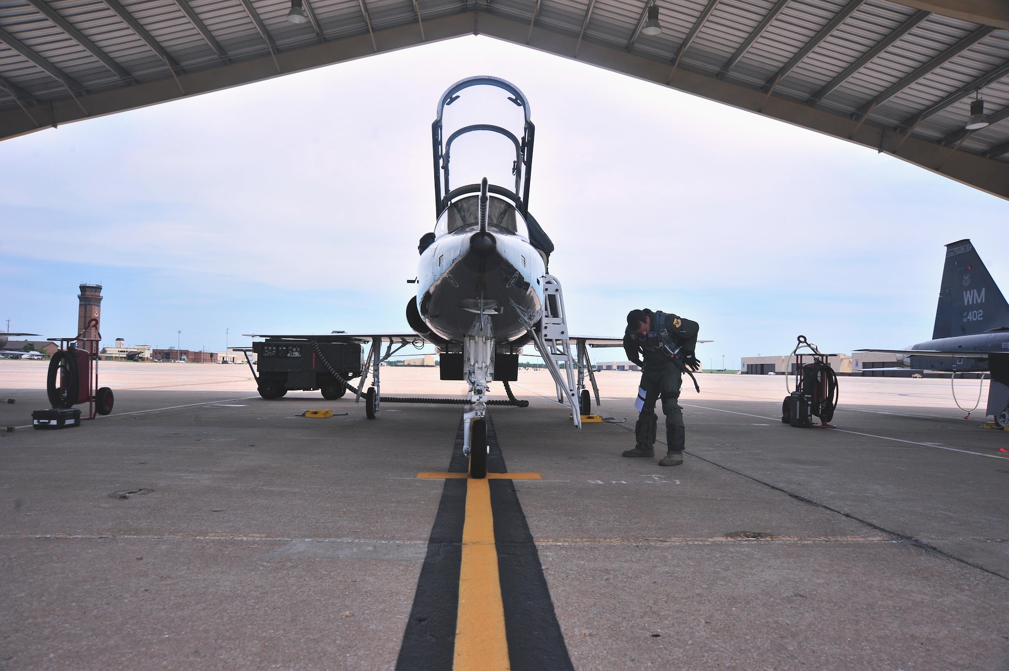U.S. Air Force Maj. Michael Granberry, the 394th Combat Training Squadron T-38 Talon assisted director of operations of the Companion Trainer Program (CTP), adjusts his gear prior to boarding a T-38 Talon aircraft at Whiteman Air Force Base, July 12, 2016. Unsecured gear during in-flight emergencies can lead to complications during egress procedures. 