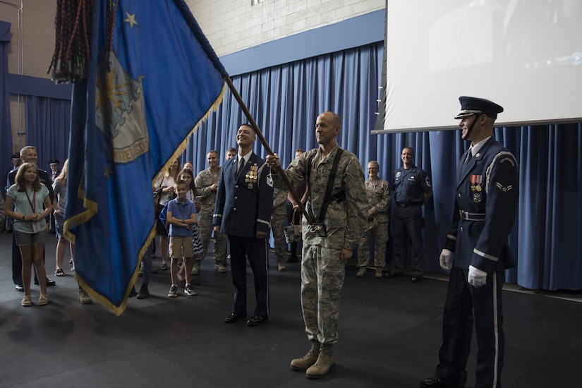 Col. E. John Teichert, 11th Wing and Joint Base Andrews commander, gets instructed on how to properly hold the Air Force flag by members of the U.S. Air Force Honor Guard at Joint Base Anacostia-Bolling in Washington, D.C., Aug. 9, 2016. The purpose of the visit was for Teichert and Chief Master Sgt. Beth Topa, 11th WG command chief master sergeant, to become more familiar with the U.S. Air Force Band and Honor Guard missions. (U.S. Air Force Photo by Airman 1st Class Rustie Kramer)