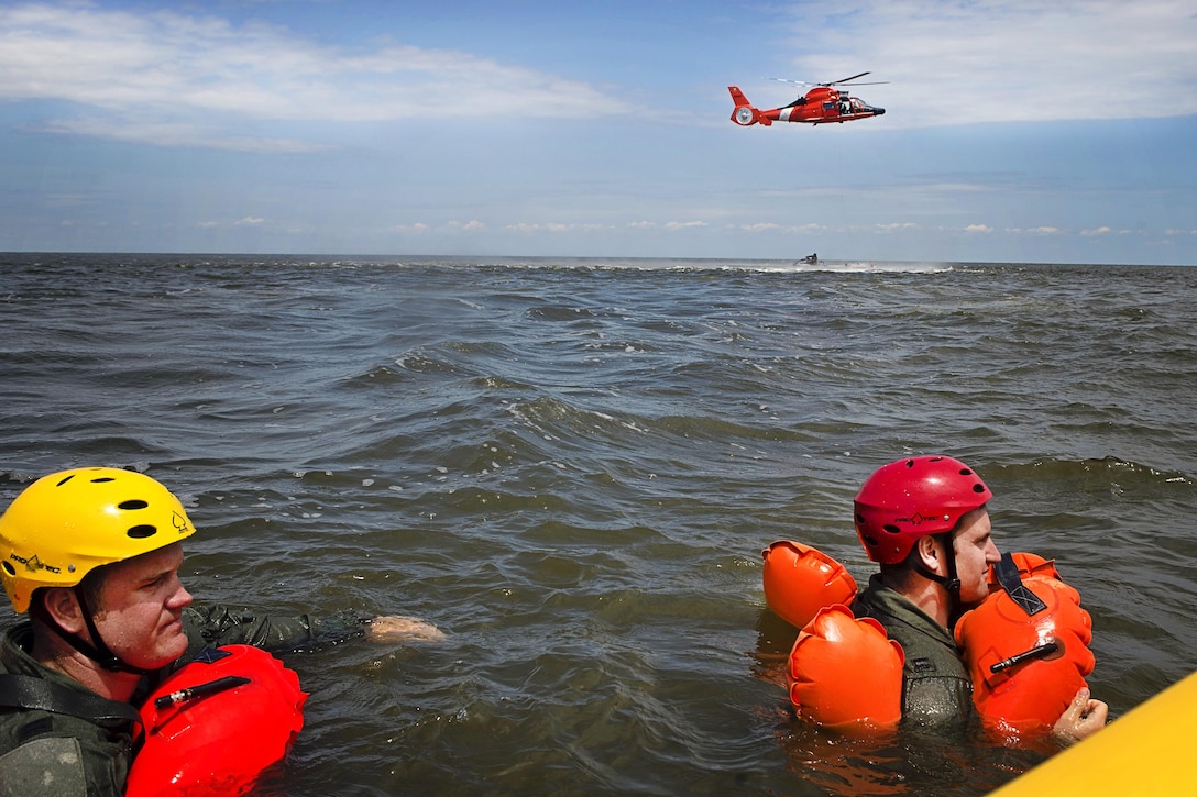 Air Force Capts. Eric Steen, left, and Paul Deadman tread water while waiting to practice helicopter extraction during water survival training at Bowers Beach, Del., Aug. 6, 2016. Steen is a pilot assigned to the 3rd Airlift Squadron; Deadman is a pilot assigned to the 709th Airlift Squadron. Air Force photo by Tech. Sgt. Nathan Rivard