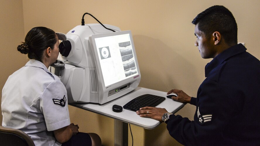 Senior Airman Jeffrey Saliba, right, 60th Aerospace Medicine Squadron public health technician, performs an eye exam at Travis Air Force Base, Calif., Aug. 1, 2016. (U.S. Air Force photo by Senior Airman Amber Carter)