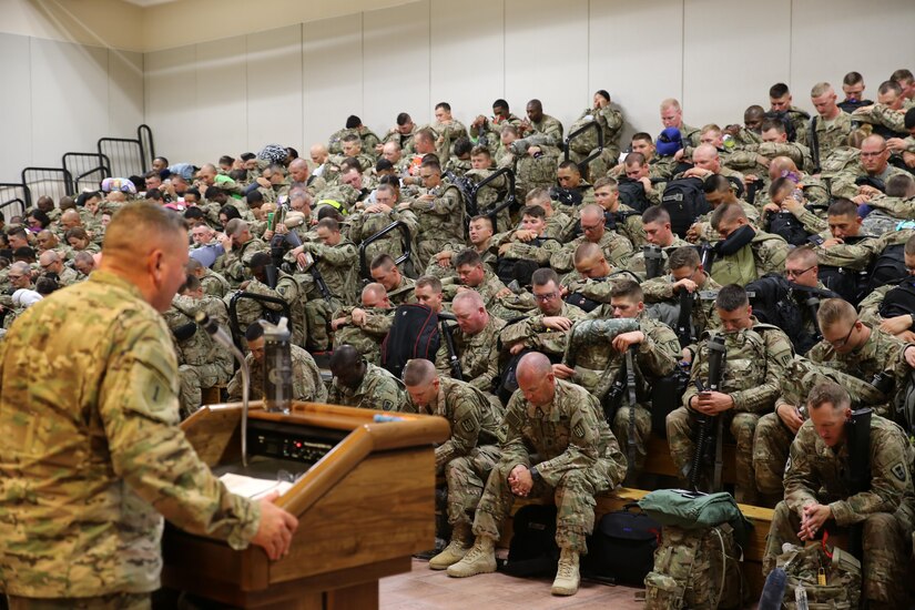 Soldiers assigned to the 389th Engineer Company and the 176th Engineer Brigade are led in prayer during the farewell brief at the Silas L. Copeland Airfield Control Group moments before boarding their flight to the Middle East July 29.