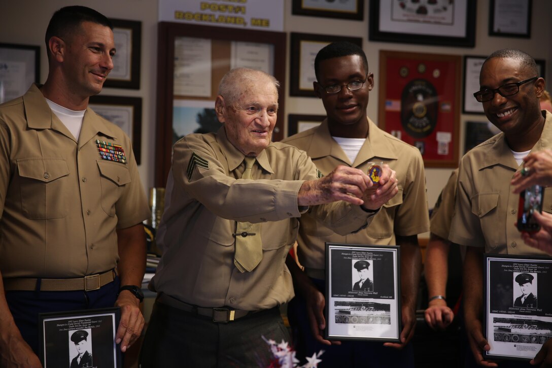 Retired Marine Sgt. Leory Peasley (left), an Iwo Jima veteran, poses for a photo with the Marines aboard the USS Oak Hill (LSD-51) at the American Legion in Rockland, ME, Aug. 6, 2016. The American Legion hosted events for the service members in town during Lobster Fest 2016. The Marines and Sailors with Combat Logistics Battalion 8, 2nd Marine Logistics Group, aboard the USS Oak Hill, were in port Aug. 3-7 to participate in the festival and display the expeditionary capabilities of the Navy-Marine Corps team. (U.S. Marine Corps photo by Sgt. Olivia McDonald)
