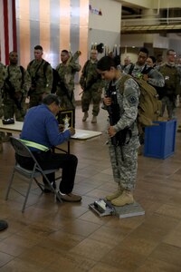 Soldiers with Headquarters and Headquarters Company, 96th Military Police Battalion, U.S. Army Reserve are weighed, manifested and processed prior to boarding a flight at the Silas L. Copeland Arrival/Departure Airfield Control Group here July 20.