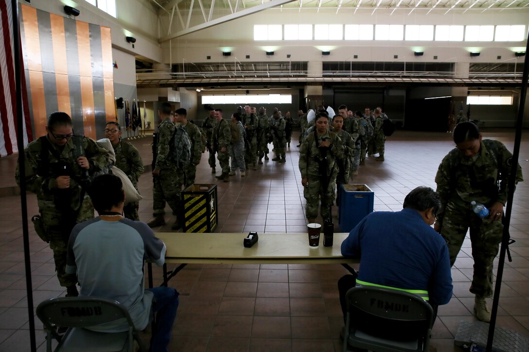 Soldiers with Headquarters and Headquarters Company, 96th Military Police Battalion, U.S. Army Reserve are weighed, manifested and processed prior to boarding a flight at the Silas L. Copeland Arrival/Departure Airfield Control Group here July 20.