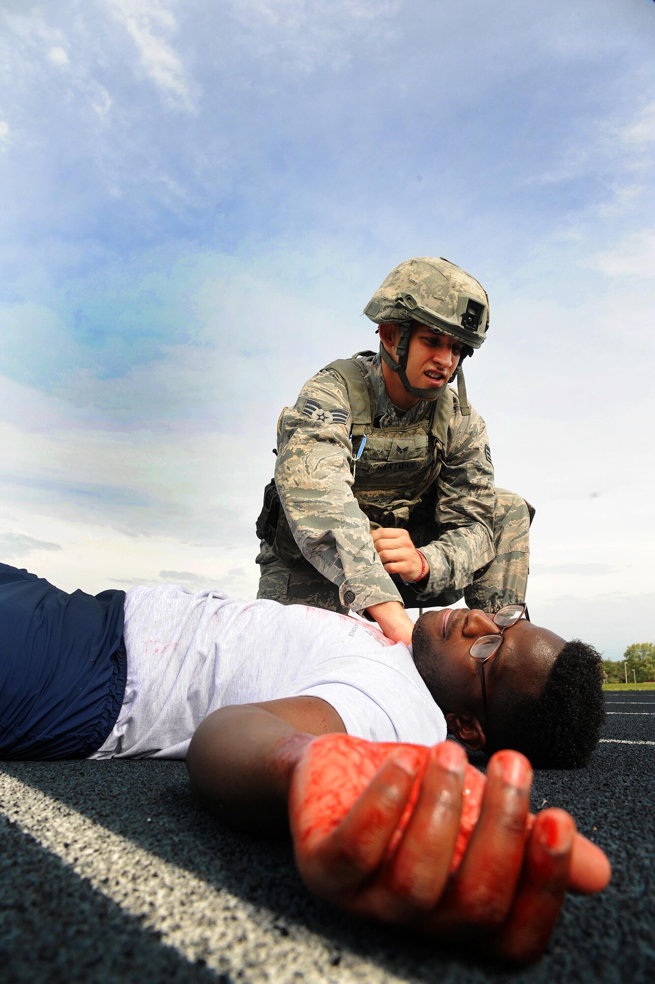 U.S. Air Force Senior Airman Kevin Hartman, a 509th Security Forces Squadron training instructor, checks Staff Sgt. Ramel Waden, a 509th Munitions Squadron unit training manager, for a pulse during an active shooter exercise at Whiteman Air Force Base, Mo., Aug. 5, 2016. The bi-annual exercise helps Whiteman personnel practice and train proper response procedures in order to reduce the risk of harm and provide direction for all base personnel in an active shooter situation.