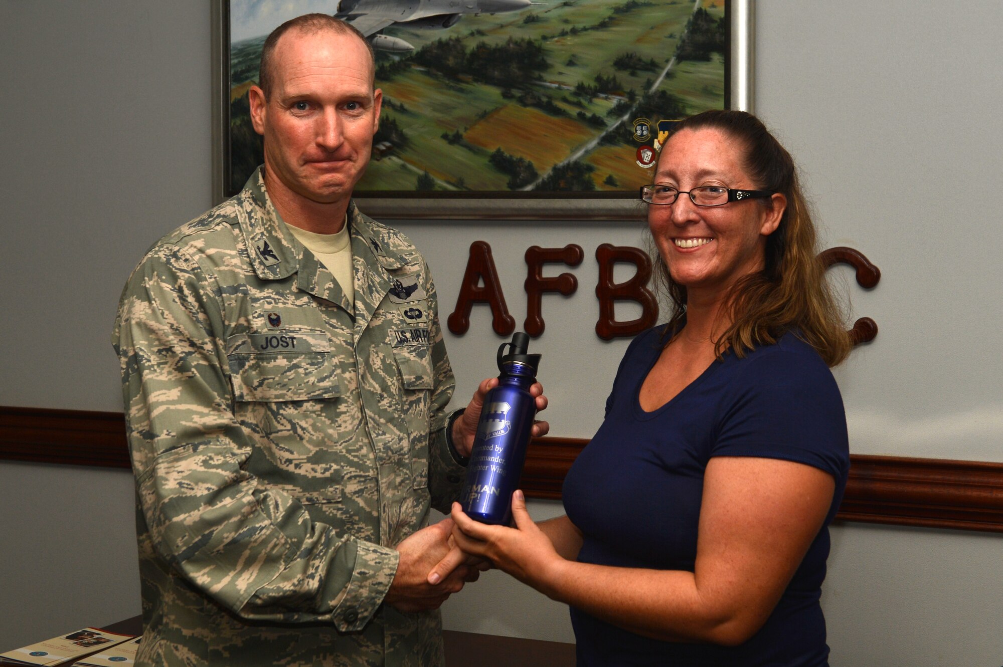 Laura Jones, 20th Logistics Readiness Squadron logistics readiness technician, receives an Airman Up! award from U.S. Air Force Col. Stephen Jost, 20th Fighter Wing commander, at Shaw Air Force Base, S.C., Aug. 3, 2016. The Airman Up! campaign challenges Airmen – enlisted, officer, and civilian – to push themselves toward personal development and build upon their resiliency. (U.S. Air Force photo by Airman 1st Class Christopher Maldonado)