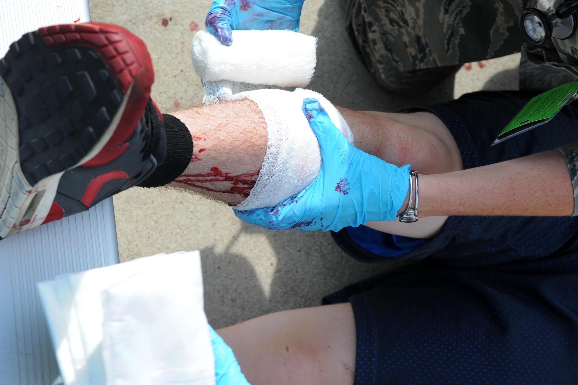 U.S. Air Force Capt. Kallyn Harencak, a 509th Medical Operations Squadron flight surgeon, wraps gauze around a victim’s simulated wound during an active shooter exercise at Whiteman Air Force Base, Mo., Aug. 5, 2016. The “victims” had moulage wounds put on them so the first responders could determine the urgency of each injury. 