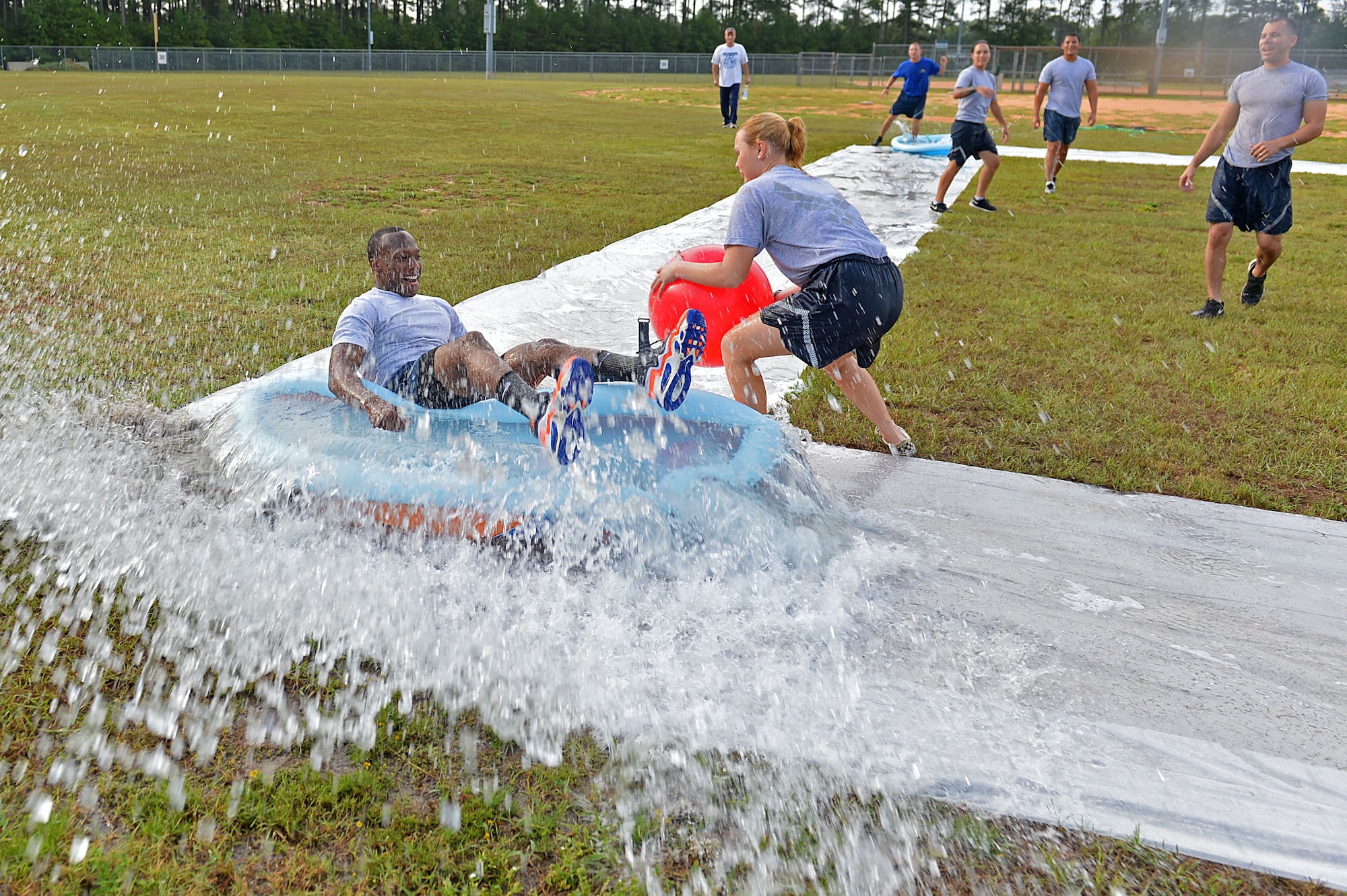 U.S. Air Force Senior Airman Dominique McNeal, 20th Communications Squadron unit deployment manager, splashes into a pool during a Comprehensive Airman Fitness sports day at Shaw Air Force Base, S.C., Aug. 10, 2016. Airmen assigned to the 20th Fighter Wing participated in a number of sports including softball and slip-and-slide kickball. (U.S. Air Force photo by Airman 1st Class Christopher Maldonado)