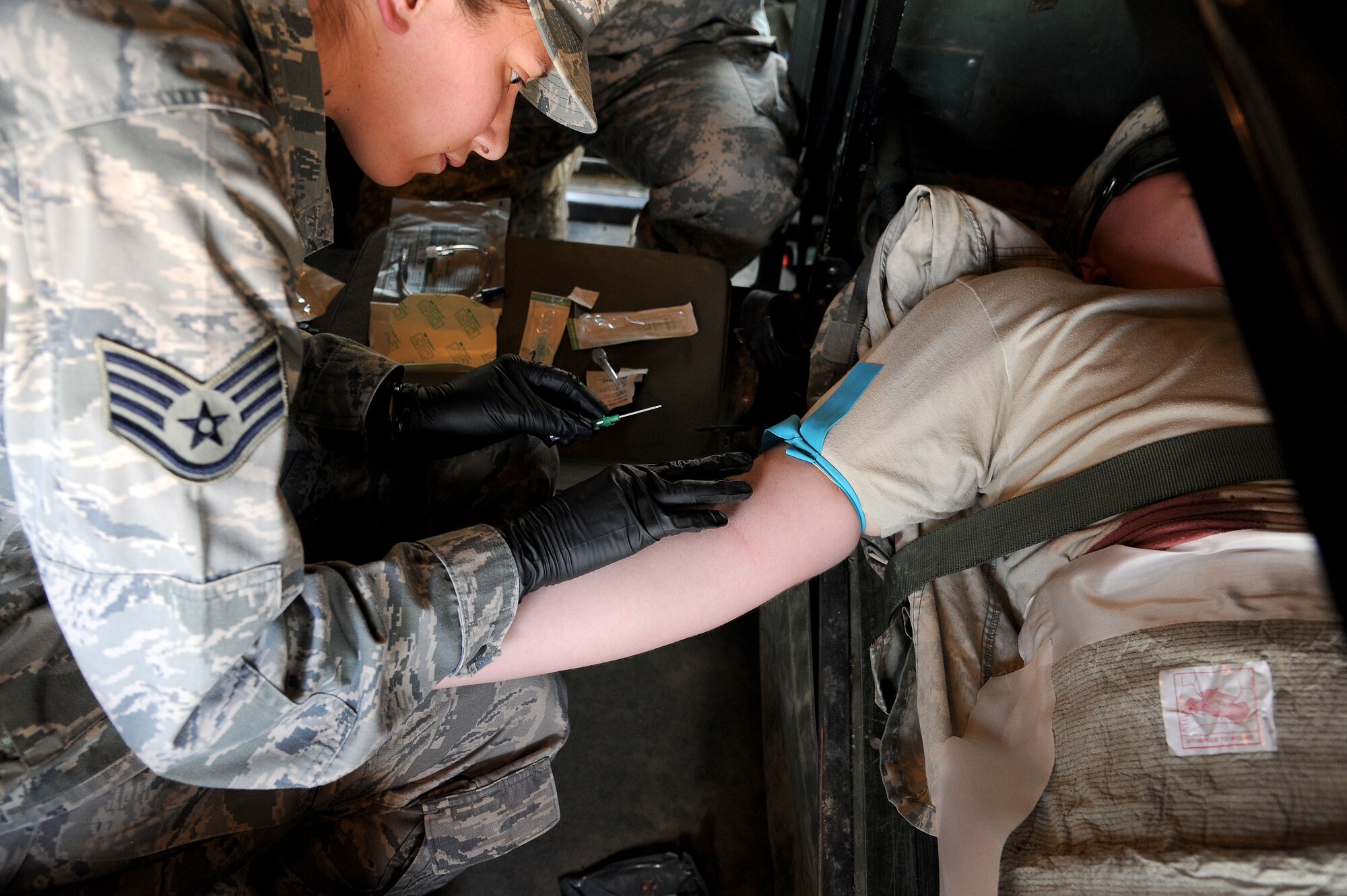 FORT CARSON, Colo. – Air Force Reserve Staff Sgt. Sharon Murphy, 302nd Aeromedical Evacuation Squadron medical technician, inserts an IV into a simulated patient while inside a M997 Field Litter Ambulance during a combat medical training exercise, July 16, 2016 here. Murphy is training in combat casualty care procedure to prepare for real world wartime missions. The Air Force Reserve Command’s 302ndASTS Critical Care Air Transport Team trained jointly with the Army National Guardsmen from the 928th Area Support Medical Company in preparation to support the 82nd Airborne Division Joint Readiness Training Center later this year. (U.S. Air Force photo/Staff Sgt. Amber Sorsek)