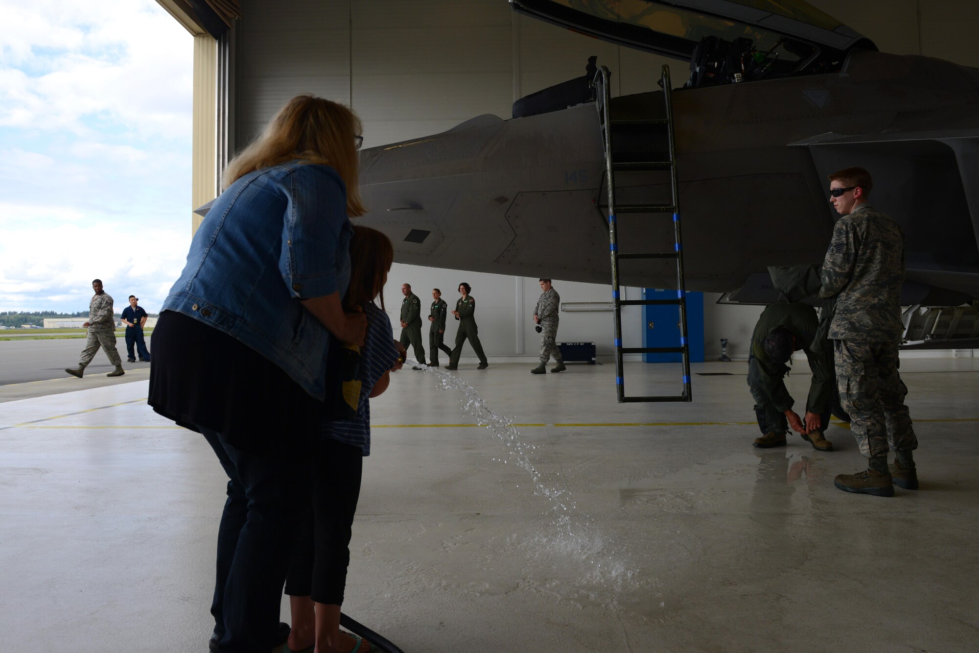 Air Force Lt. Gen. Russell Handy removes his aircrew flight equipment as he prepares to get a ceremonial hose-6down after his final flight as Alaskan Command, Alaskan North American Aerospace Defense Region and 11th Air Force commander at Joint Base Elmendorf-Richardson, Alaska, Aug. 10, 2016. Handy is the senior military officer in Alaska, responsible for the integration of all military activities in the Alaska joint operations area, synchronizing the activities of more than 21,000 active-duty and Reserve forces from all services. (U.S. Air Force photo by Airman 1st Class Javier Alvarez)