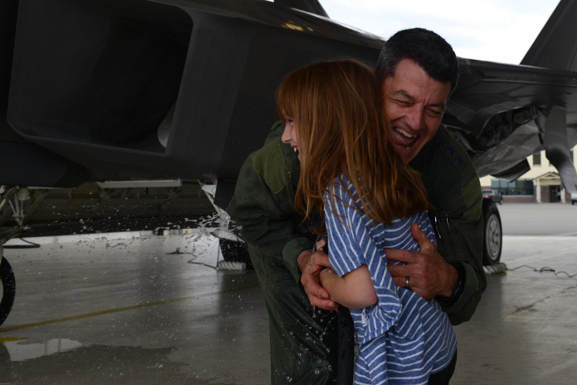 Air Force Lt. Gen. Russell Handy hugs Makayla Owens, 6, after his final flight as Alaskan Command, Alaskan North American Aerospace Defense Region and 11th Air Force commander at Joint Base Elmendorf-Richardson, Alaska, Aug. 10, 2016. Handy is the senior military officer in Alaska, responsible for the integration of all military activities in the Alaska joint operations area, synchronizing the activities of more than 21,000 active-duty and Reserve forces from all services. (U.S. Air Force photo by Airman 1st Class Javier Alvarez)
