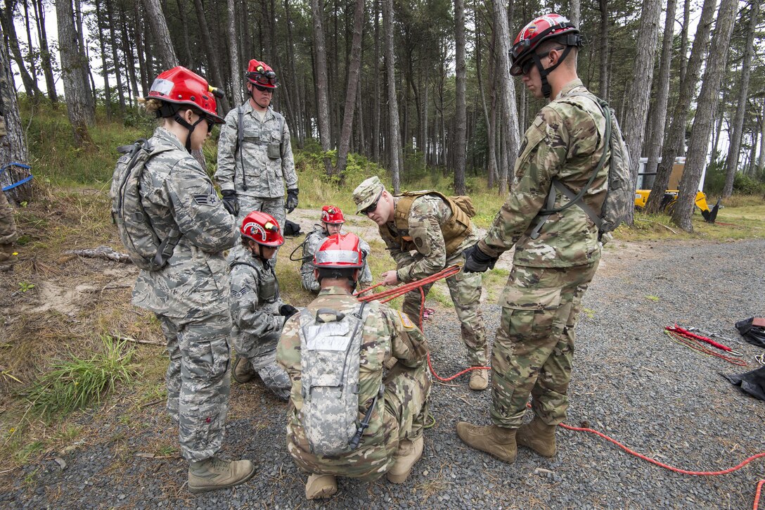 Soldiers and airmen listen as an evaluator explains how to tie a rope around a victim being hoisted from a tower of rubble during a joint exercise evaluation at Camp Rilea in Warrenton, Ore., Aug. 2, 2016. The soldiers and airmen, assigned to the Colorado National Guard’s search and extraction teams, will practice search and extraction techniques and medical procedures to save lives in the event of a domestic emergency. Air National Guard photo by Staff Sgt. Bobbie Reynolds