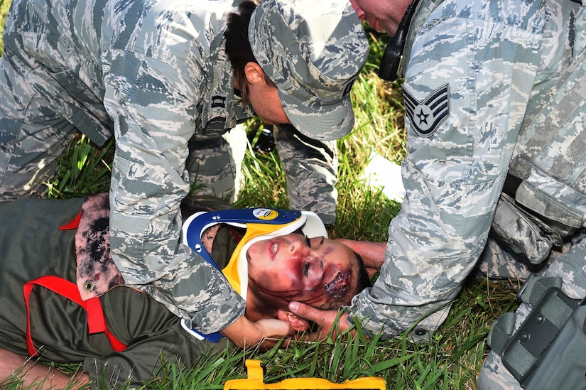 Capt. Jamie Owsiany, 779th Aeromedical Squadron physician assistant, and Staff Sgt. Thomas Burton, 11th Security Forces Group response force leader, apply a neck brace to Airman 1st Class Danielle Jenkinson, 811th Security Forces Presidential Airlift Group entry controller, who acts as an aircraft crash victim for the Major Accident Response Exercise at Joint Base Andrews, Md., Aug. 11, 2016. The MARE is an annual training requirement for a base to test its readiness and response capabilities. (U.S. Air Force photo by Senior Airman Joshua R. M. Dewberry)