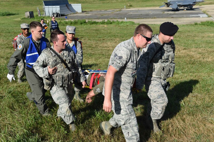 79th Medical Wing medical staff and 11th Wing Security Forces members carry an aircraft accident victim to safety for the Major Accident Response Exercise at Joint Base Andrews, Md., Aug. 11, 2016. The MARE is an annual training requirement for a base to test its readiness and response capabilities. (U.S. Air Force photo by Senior Airman Joshua R. M. Dewberry)