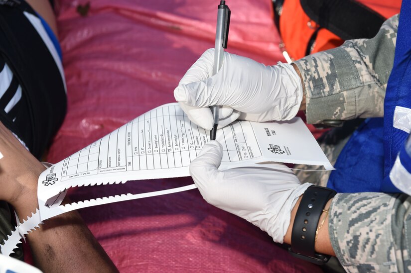 Medical technicians take notes of injury status information of victims for the Major Accident Response Exercise at Joint Base Andrews, Md., Aug. 11, 2016. The MARE is an annual training requirement for a base to test its readiness and response capabilities. (U.S. Air Force photo by Senior Airman Joshua R. M. Dewberry)