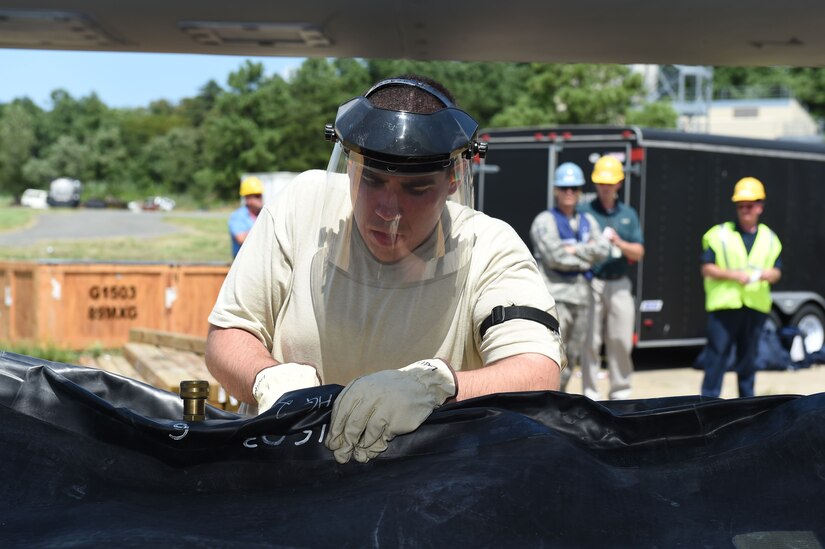 Staff Sgt. Justin Episcopo, 113th Wing Maintenance Squadron crew chief, attaches a pressure hose to a large balloon to simulate lifting a crashed F-16 aircraft from an accident site for the Major Accident Response Exercise at Joint Base Andrews, Md., Aug. 11, 2016. The MARE is an annual training requirement for a base to test its readiness and response capabilities. (U.S. Air Force photo by Senior Airman Joshua R. M. Dewberry)