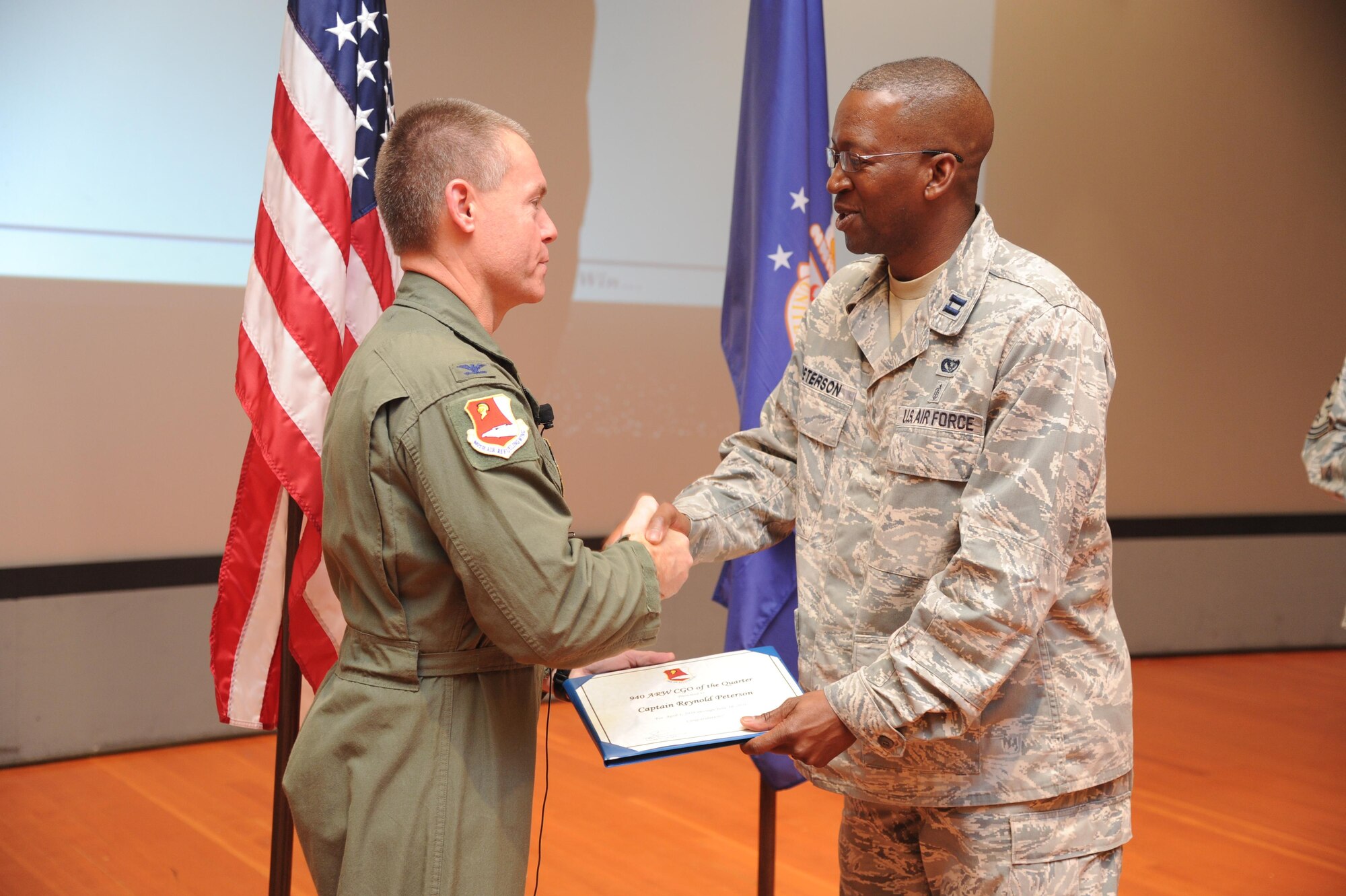 Col. Craig Peters, 940th Air Refueling Wing commander, recognizes Capt. Reynold Peterson, 940th Civil Engineering Squadron, during a Commander's Call at Beale Air Force Base, California on August 7, 2016. Peterson won Company Grade Officer of the Quarter for his outstanding efforts during the second quarter. Three other individuals were also awarded at the event for their efforts during the second quarter. (U.S. Air Force photo by Tech. Sgt. Heather Skinkle)