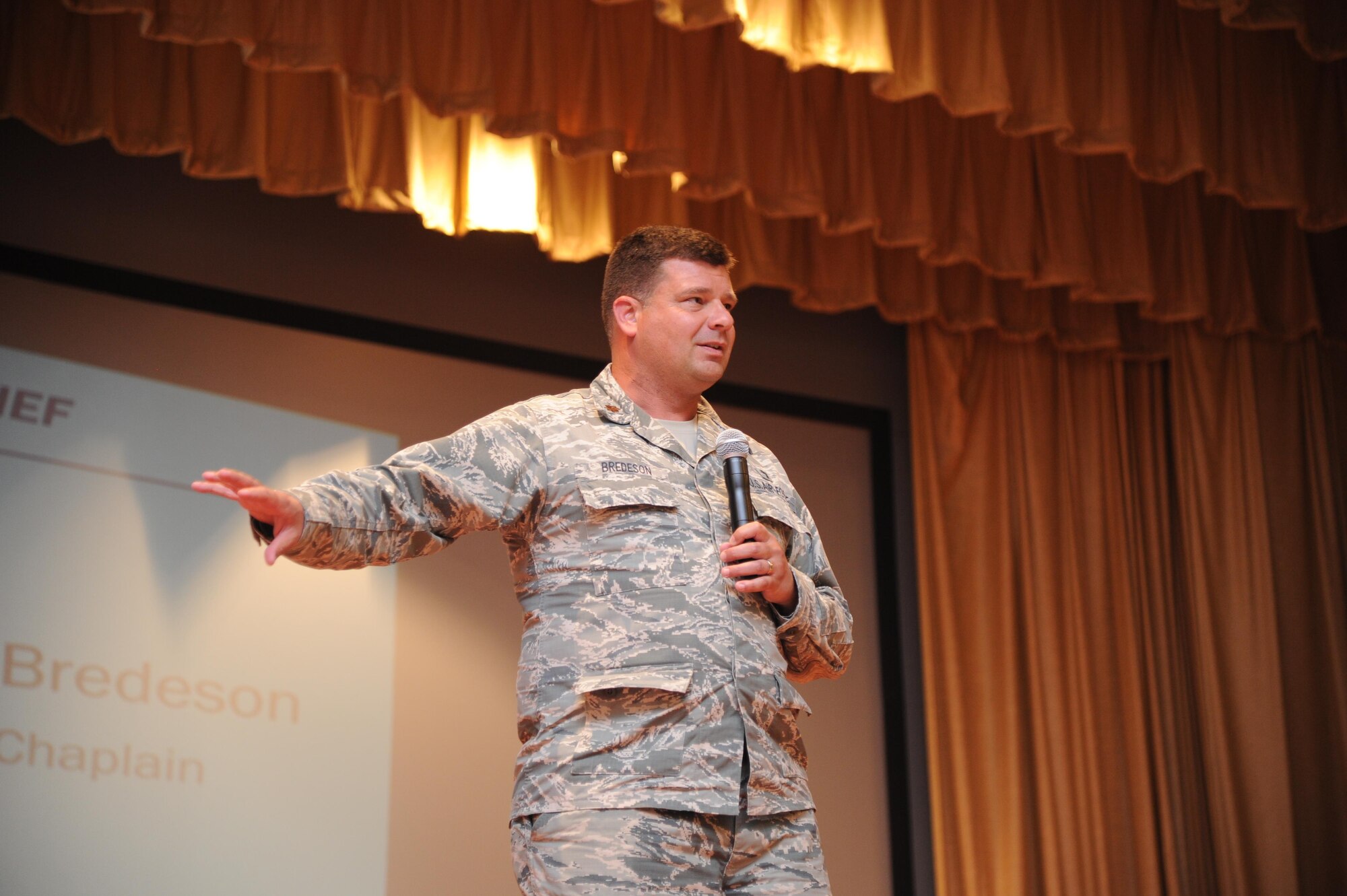 Maj. Jason Bredeson, 940th Air Refueling Wing chaplain, addresses the wing during a Commander's Call at Beale Air Force Base, California on August 7, 2016. Chaplain Bredeson used his sense of humor to captivate the audience with a story about his new puppy while also delivering useful information on chaplain services for Citizen Airmen. (U.S. Air Force photo by Tech. Sgt. Heather Skinkle)