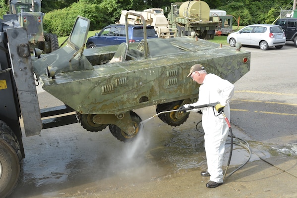 Terry Winschel, historian for the U.S. Army Engineer Research and Development Center, uses a power washer to clean off a unique prototype military vehicle designed with “tri-star” wheels. Winschel is on a mission to preserve and restore historic prototypes tested by ERDC since the 1960s.