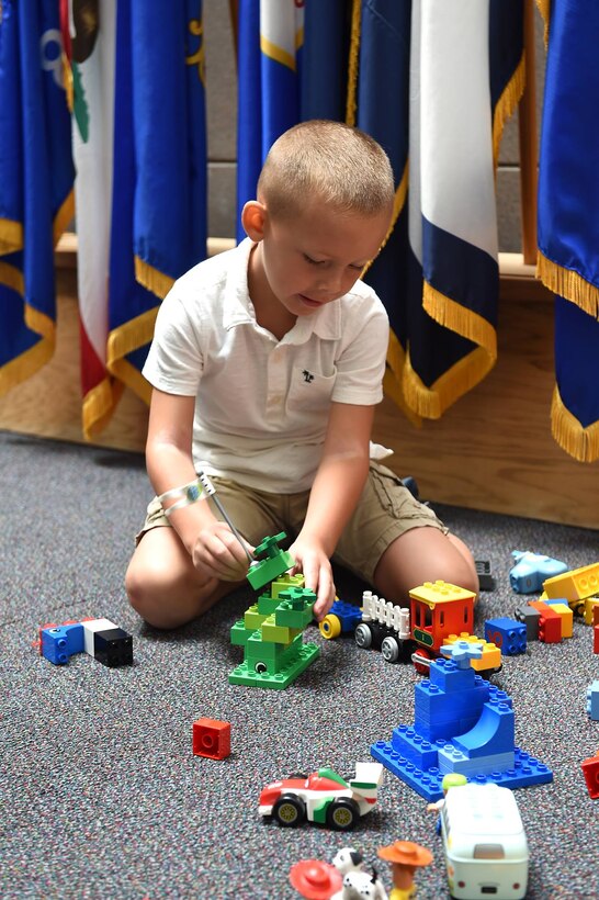 Six-year-old Casey plays with Legos during the August battle assembly while his mother attends to the Family Readiness Group snack table.
(Photo by Spc. David Lietz)