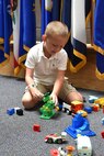 Six-year-old Casey plays with Legos during the August battle assembly while his mother attends to the Family Readiness Group snack table.
(Photo by Spc. David Lietz)
