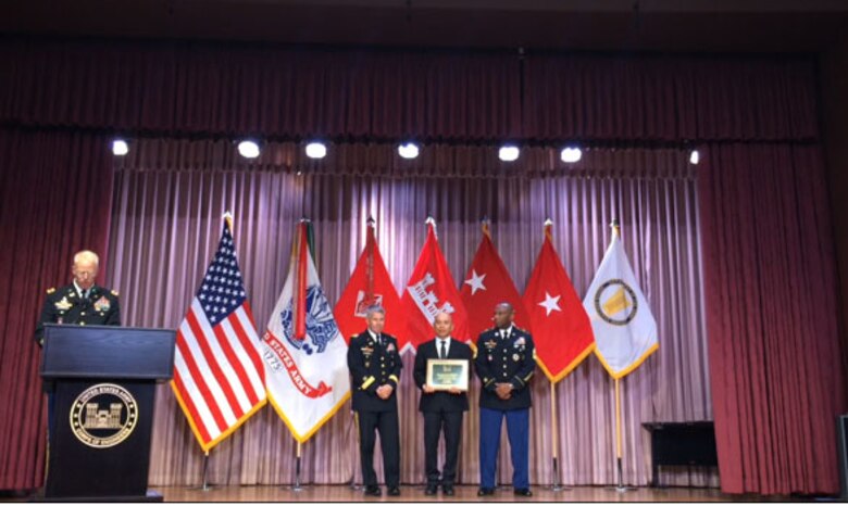 Nic Sison, a construction representative with the Middle East District, accepts the USACE Hard Hat of the Year Award Aug. 5.