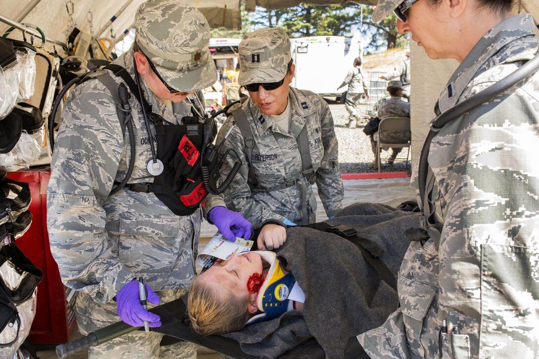 From left to right: Air Force Maj. Robert J. Ochsner, Capt. Alex P. Peterson and 2nd Lt. Margaret J. Mazzarello examine a patient in triage for internal and external wounds during a joint exercise evaluation at Camp Rilea, Warrenton, Ore., Aug. 4, 2016. Ochsner is a basic life support physician, Peterson and Mazzarello are nurse practitioners assigned to the Colorado National Guard’s 140th Medical Group. Air National Guard photo by Staff Sgt. Bobbie Reynolds 