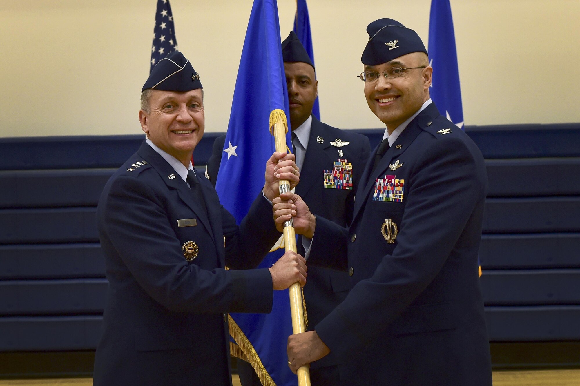 Lt. Gen. David J. Buck, Commander, 14th Air Force (Air Forces Strategic), Air Force Space Command; and Commander, Joint Functional Component Command for Space, U.S. Strategic Command, assigns command of the 460th Space Wing to Col. David N. Miller Jr., 460th SW commander, through the symbolic passing of the guidon during a ceremony August 12, 2016, at the Buckley Fitness Center on Buckley Air Force Base, Colo. The guidon is a source of pride for the wing and its exchange symbolizes the end of an era as well as the beginning of a new one. Before assuming command of the 460th SW, Miller served as the senior advisor to the Prime Minister’s Office and the Iraqi Ministry of Interior, U.S. Embassy, Baghdad, Iraq. (U.S. Air Force photo by Airman 1st Class Gabrielle Spradling/Released)